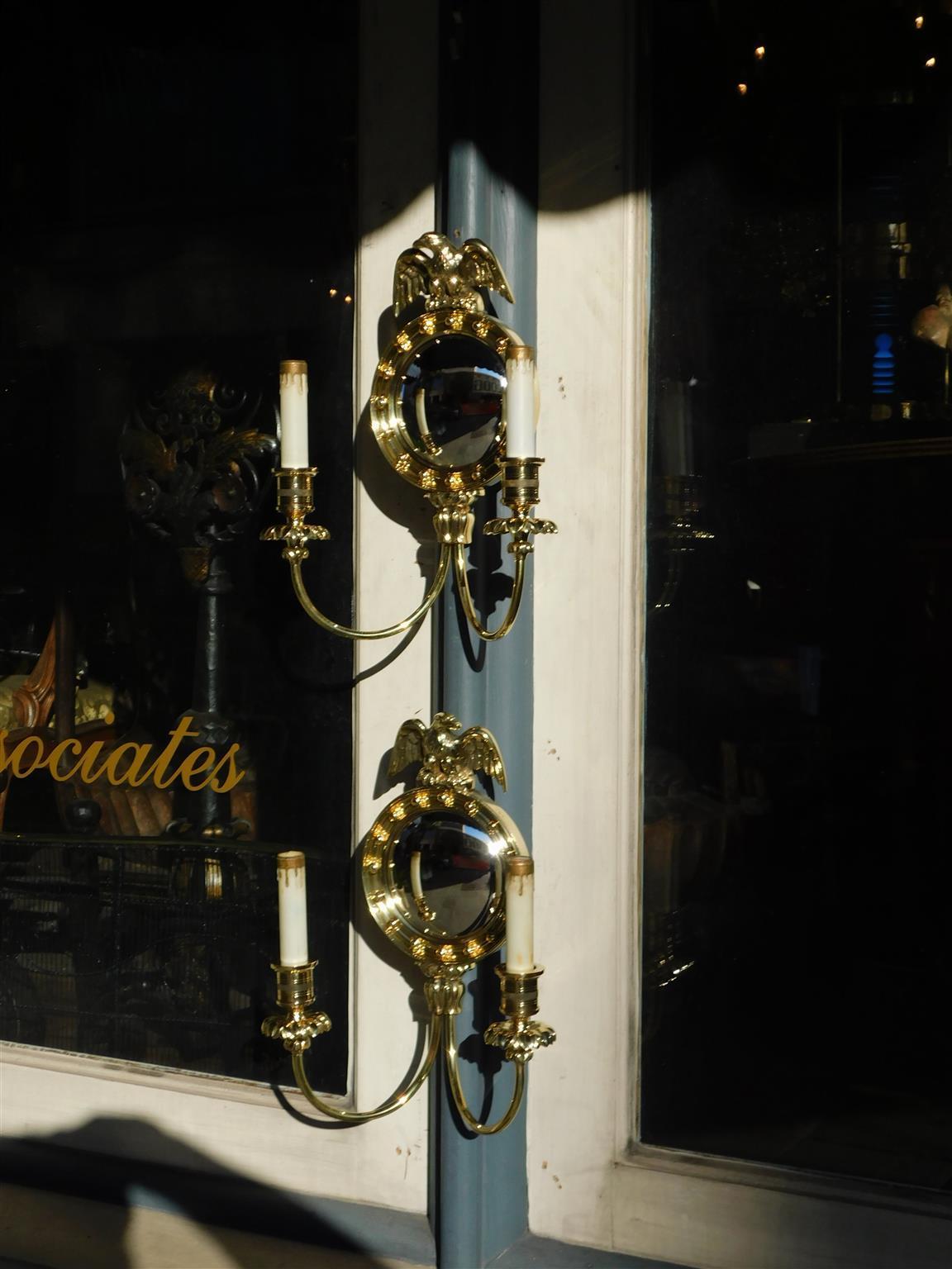 Pair of American brass eagle convex mirror two arm foliage wall sconces, Mid 19th Century. Pair of sconces were originally candle powered and have been electrified.