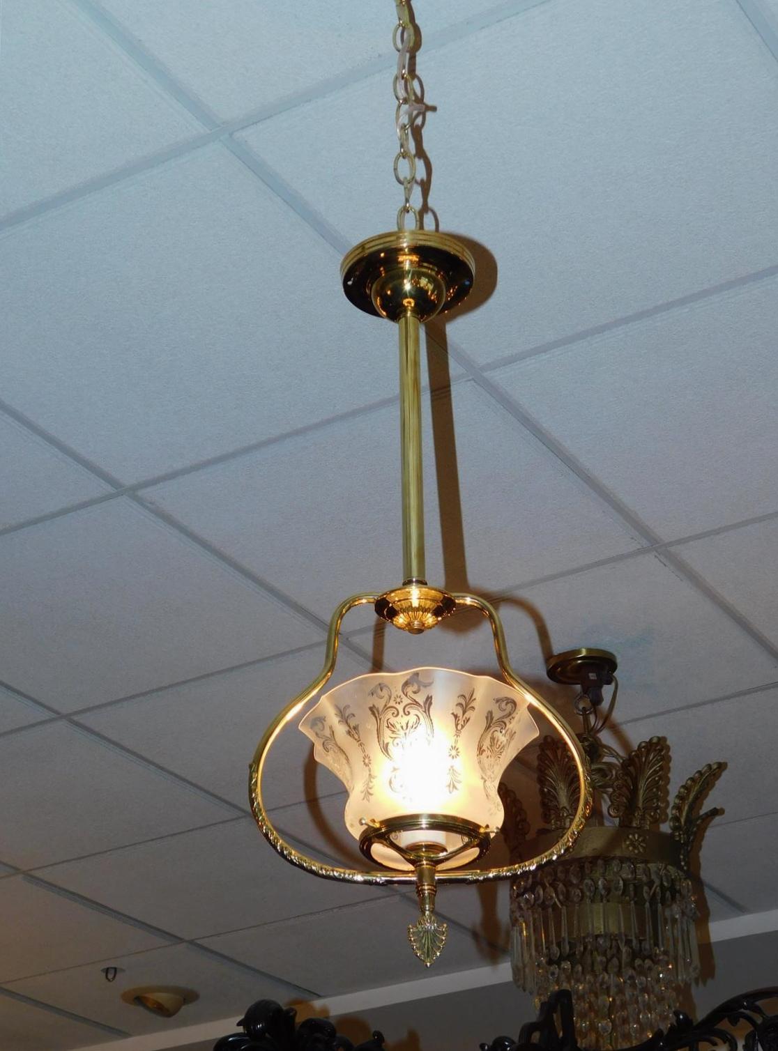 Pair of American brass foliage hall lanterns with the original frosted etched flared globes and filigree cock keys. Pair of lanterns were originally gas and have been electrified. Mid-19th century.