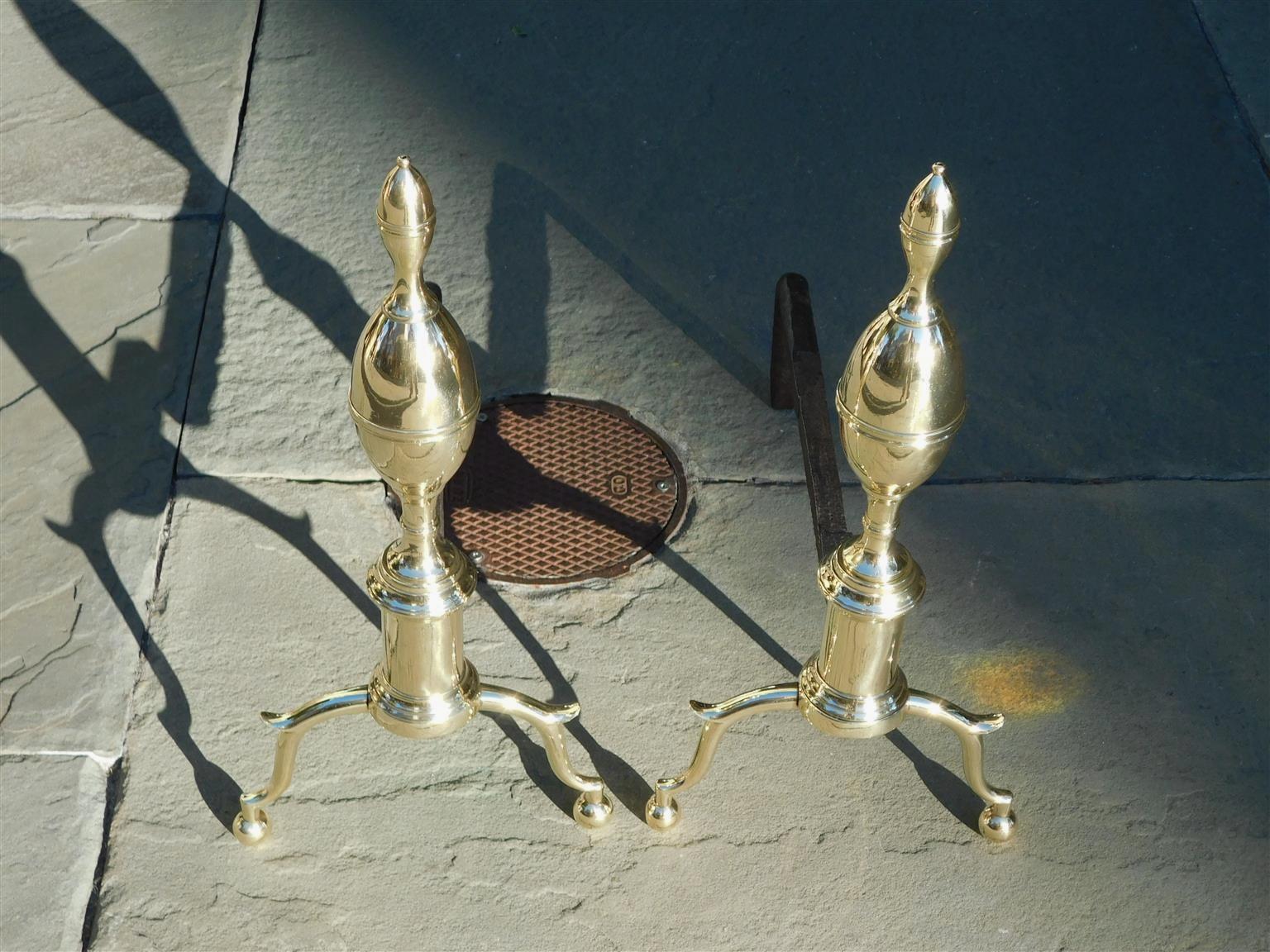 Pair of American brass lemon on lemon banded finial andirons with circular plinths, original wrought iron rear dog legs, and resting on spur legs with ball feet. New York Early 19th Century.