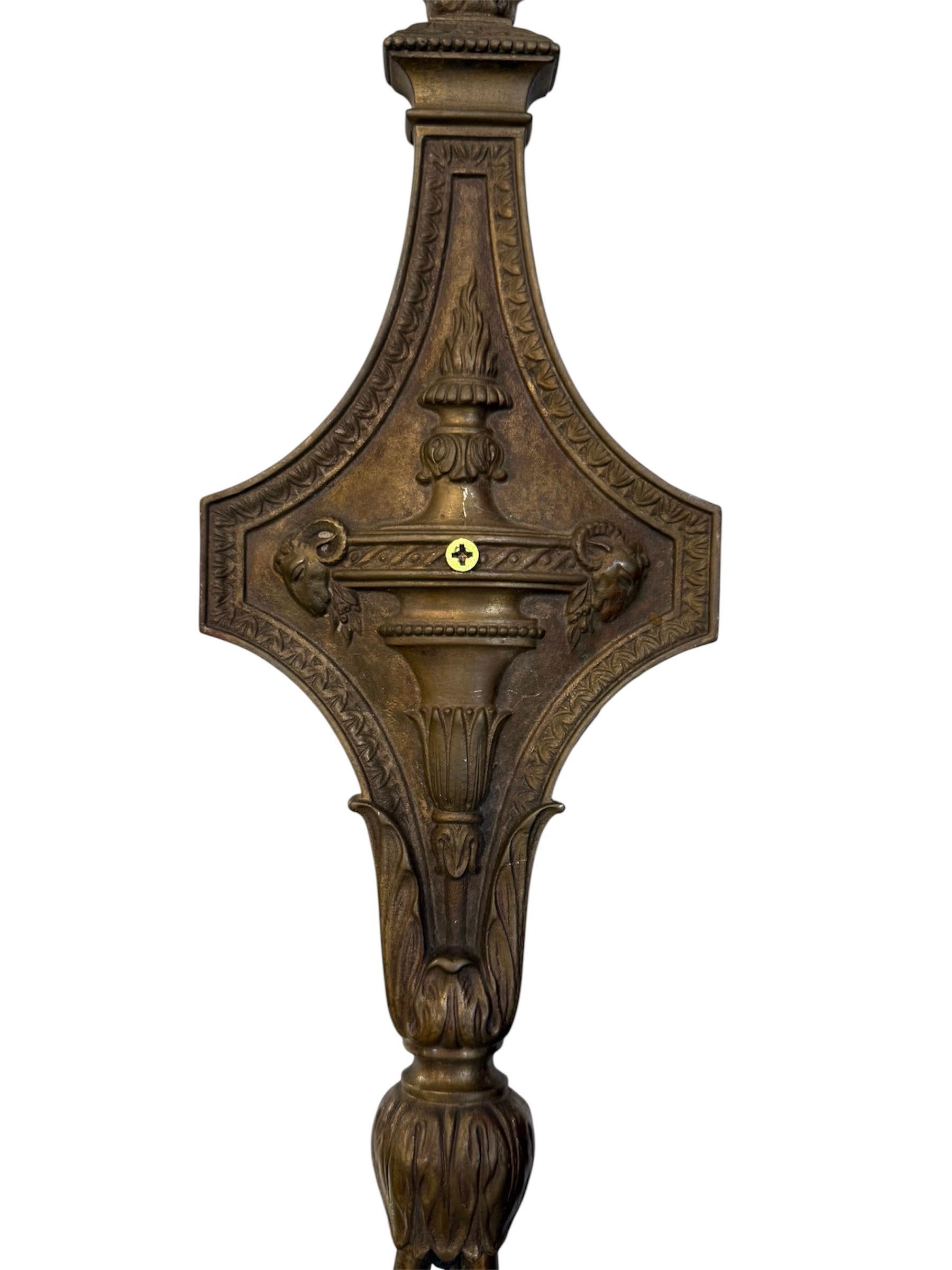 Verleihen Sie Ihren Räumen zeitlose Eleganz mit diesem exquisiten Paar amerikanischer Wandleuchten aus Messing. Jede Leuchte verfügt über eine kunstvolle, mit klassischen Motiven verzierte Rückwand, die in einer eleganten Verzierung an der Spitze