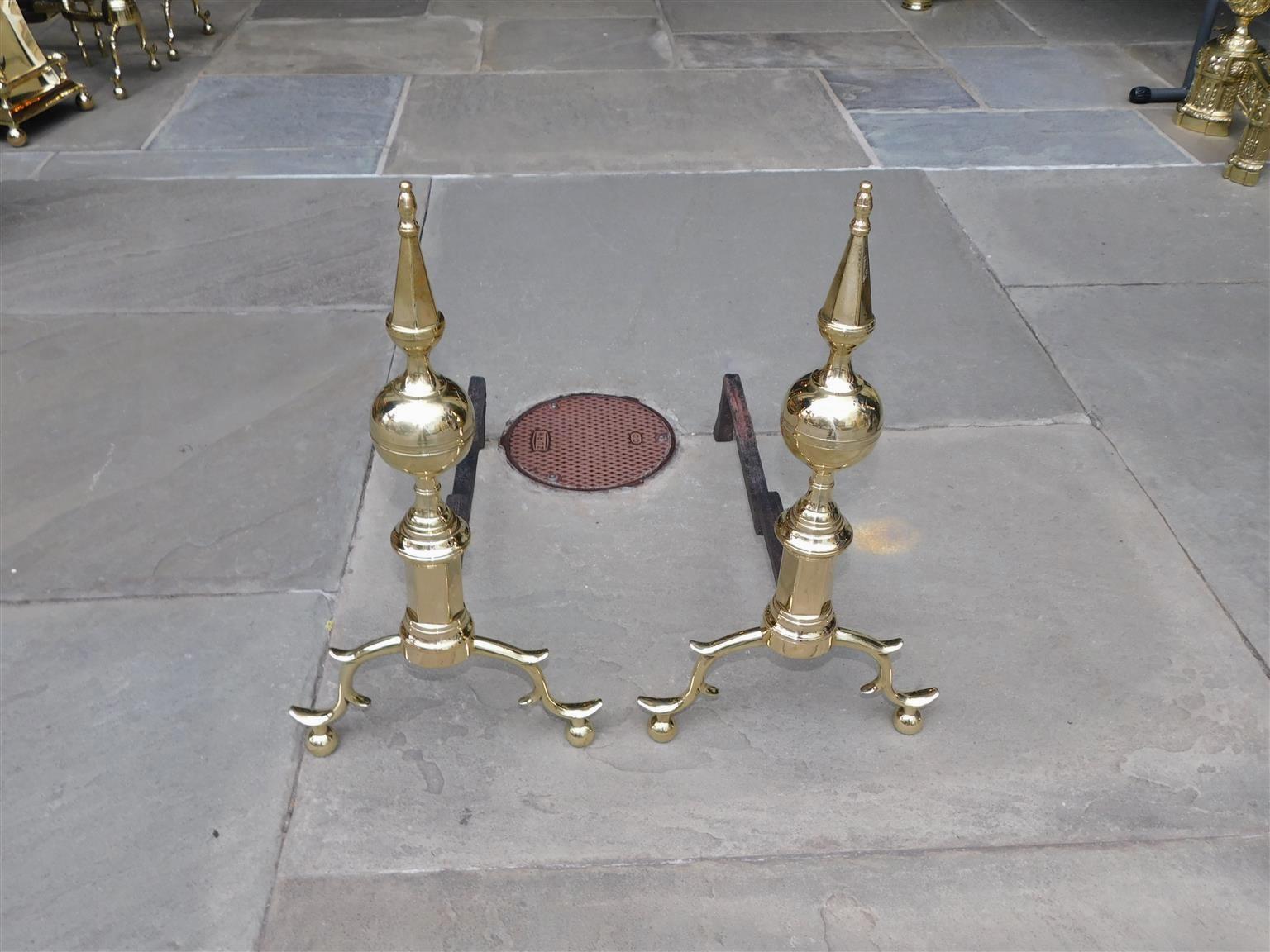 Coppia di candelabri americani in ottone con zoccolo sfaccettato, gambe a doppio sperone e piedi a sfera. La coppia ha le gambe posteriori originali in ferro battuto con il timbro del produttore D. A. Phillips, New York.  Inizio del XIX secolo