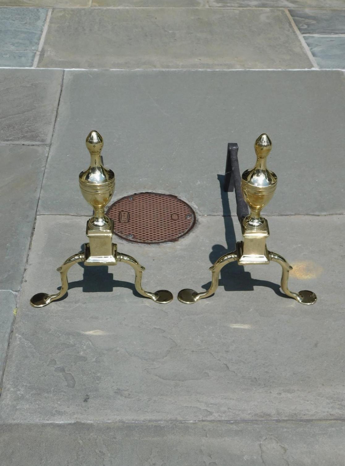 Pair of American brass flanking urn incised ringed finial andirons with squared plinths, banded spur legs and resting on the original penny feet. Late 18th Century, Philadelphia.