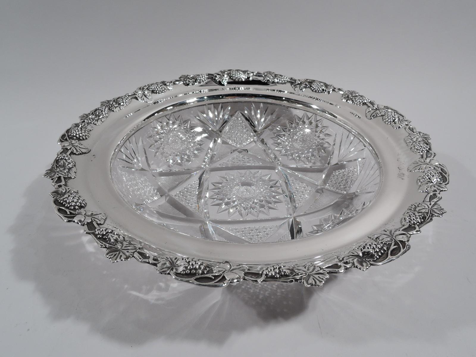 Pair of turn of the century American brilliant-cut glass bowls with sterling silver collar. Made by Wilcox (a division of International) in Meriden, Conn. Each: Curved with fans and stars bordering large star comprising diaper inset triangles.