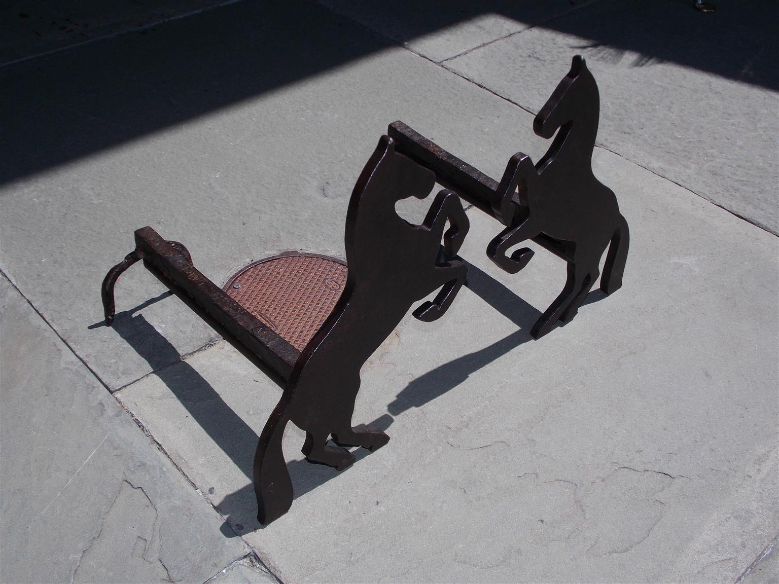 Pair of American cast and wrought iron flanking reared horse andirons with decorative horseshoe back legs, Mid-19th century.