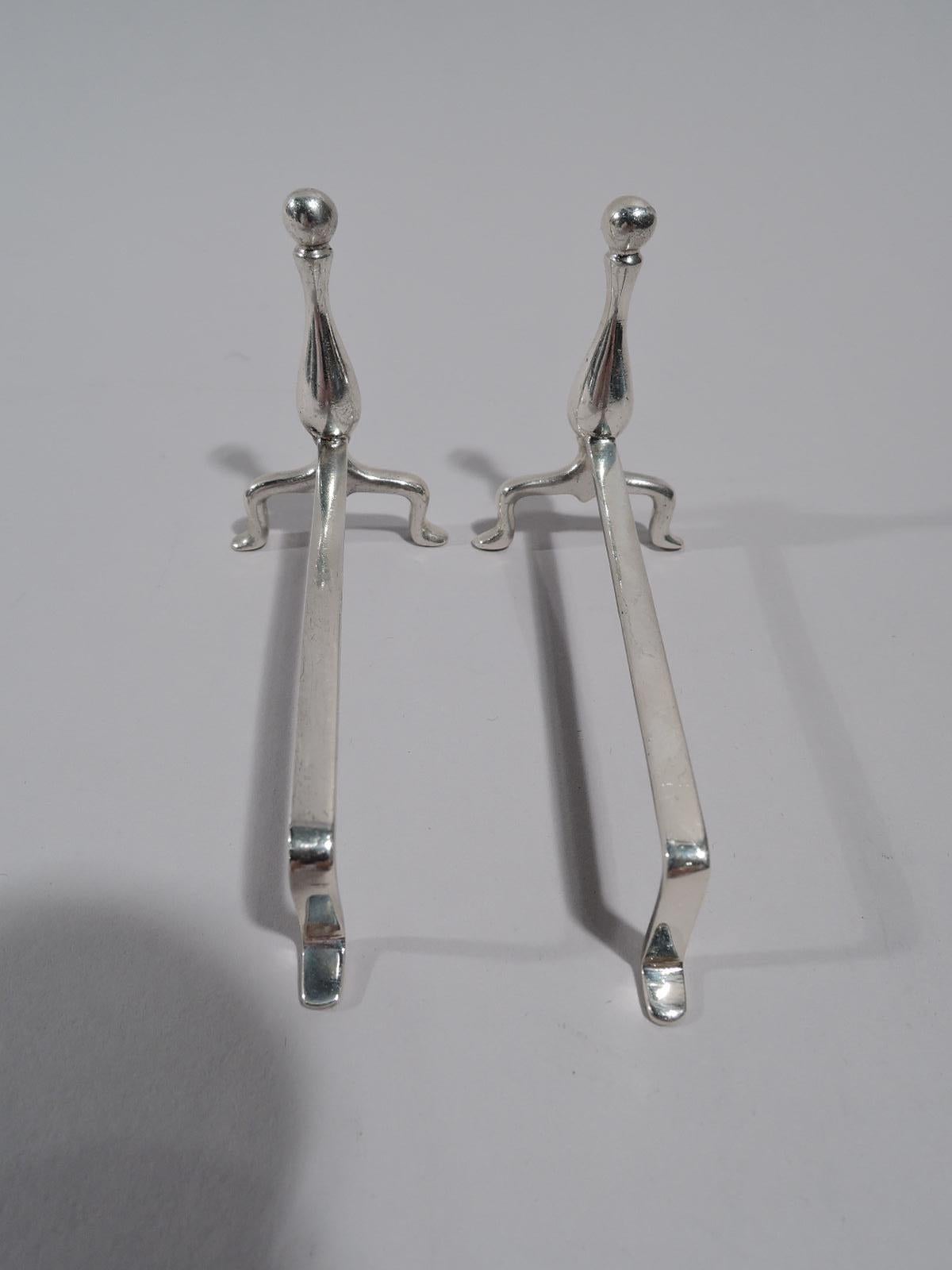 Pair of American sterling silver knife rests, circa 1920. Each: Baluster on split and spread foot mounted to horizontal rail with L-form support. Colonial Revival style in the form of old-fashioned andirons. Marked “Sterling”. Total weight: 1 troy