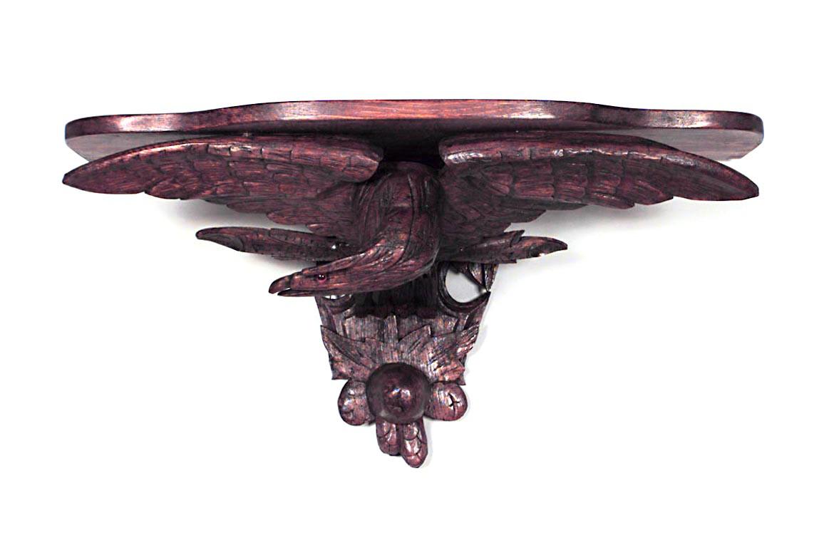 Pair of American Country pine shaped top wall shelves supported by a carved eagle with spread wings above carved fruit (19/20th Cent)

