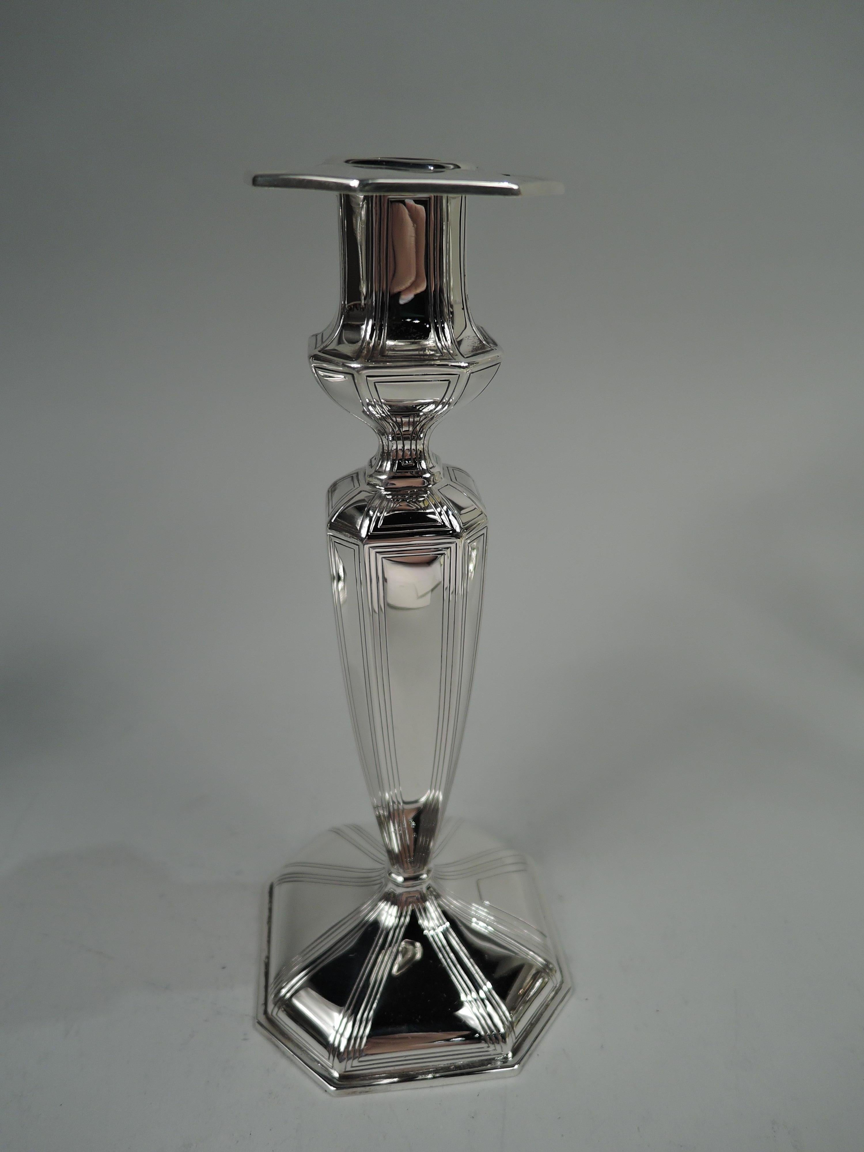 Pair of Edwardian Georgian sterling silver candlesticks, 1927. Retailed by Black, Starr & Frost in New York. Each: Bellied socket with detachable bobeche; tapering shaft on raised foot. Faceted with lined frames. Foot has applied trapezoidal mono