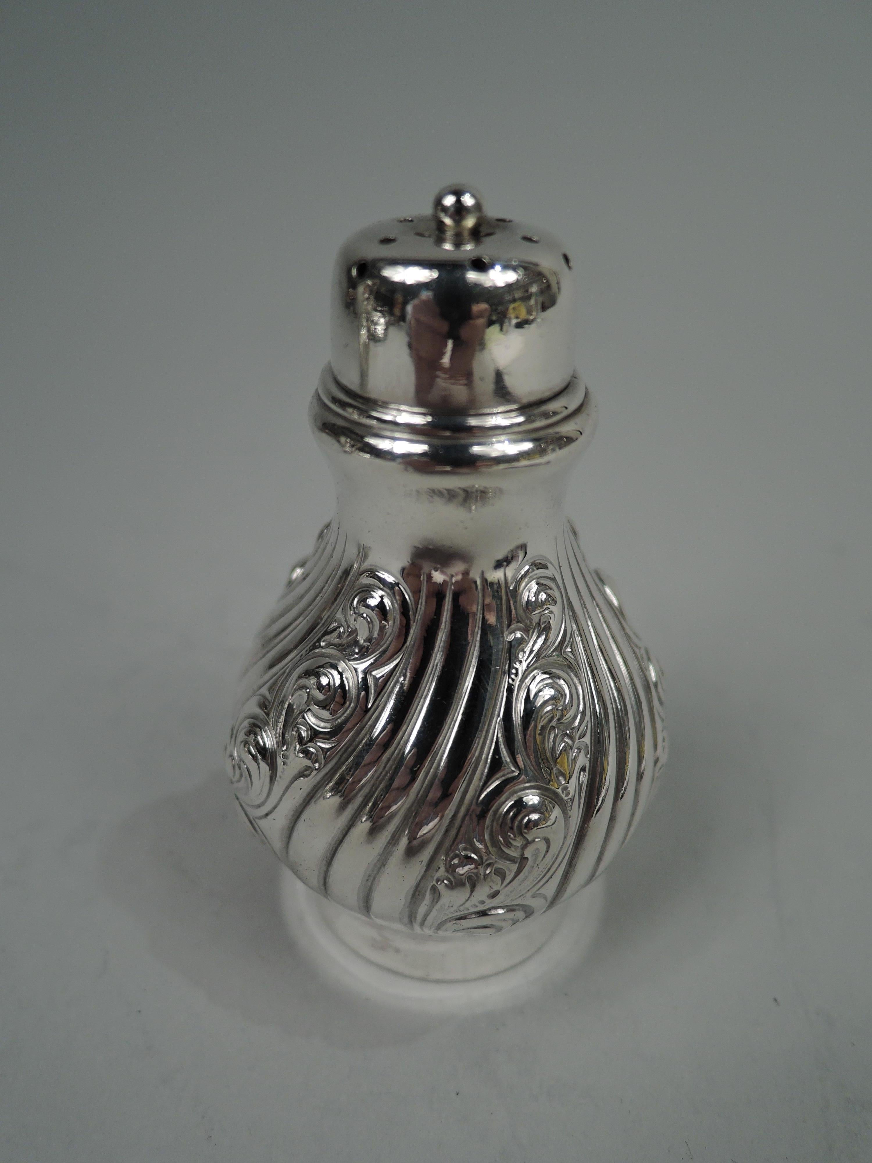 Pair of Edwardian Classical sterling silver salt and pepper shakers. Made by Dominick & Haff in New York, ca 1910. Each: Baluster with plain and narrow twisted gadroons interspersed with wide gadroons decorated with chased leafing scrollwork.