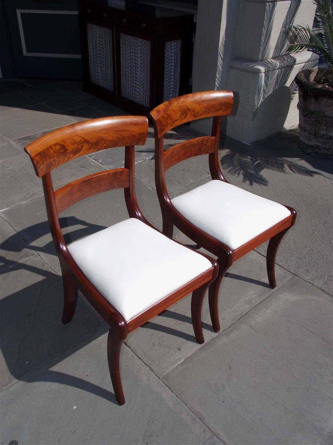 Pair of American Federal mahogany side chairs with carved splat backs, removable upholstered white muslin seats, and terminating on the original saber legs. Early 19th century.