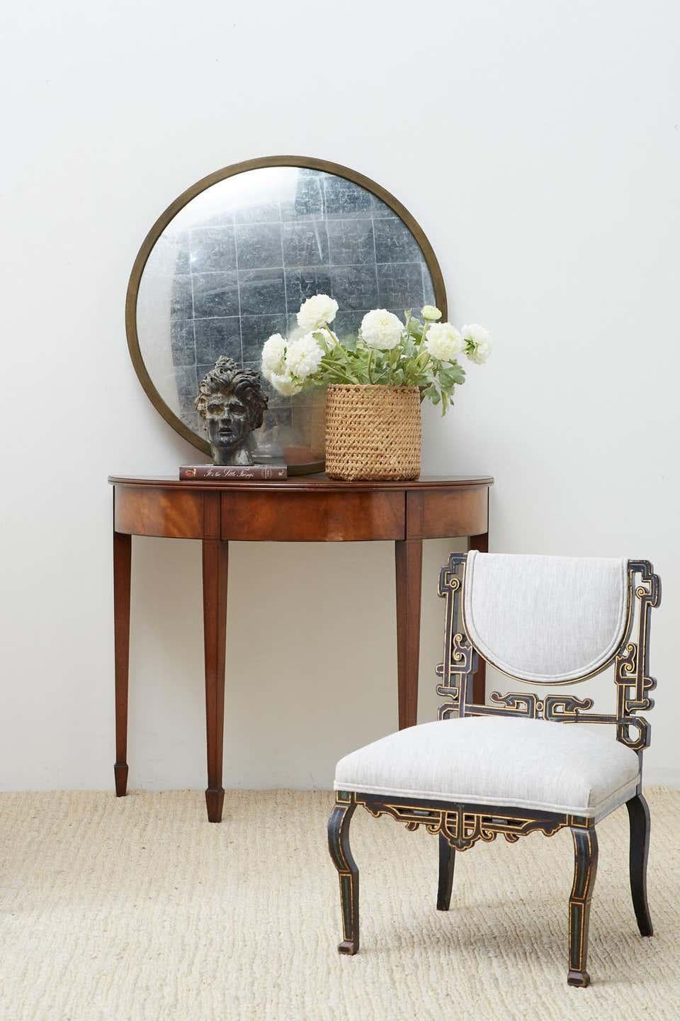 Matched pair of American Hepplewhite or Federal style demilune console tables featuring a flip-top. Constructed from mahogany with intricate neoclassical style design motifs on the frieze and delicate thread inlay of fruitwood. The flip-tops open to
