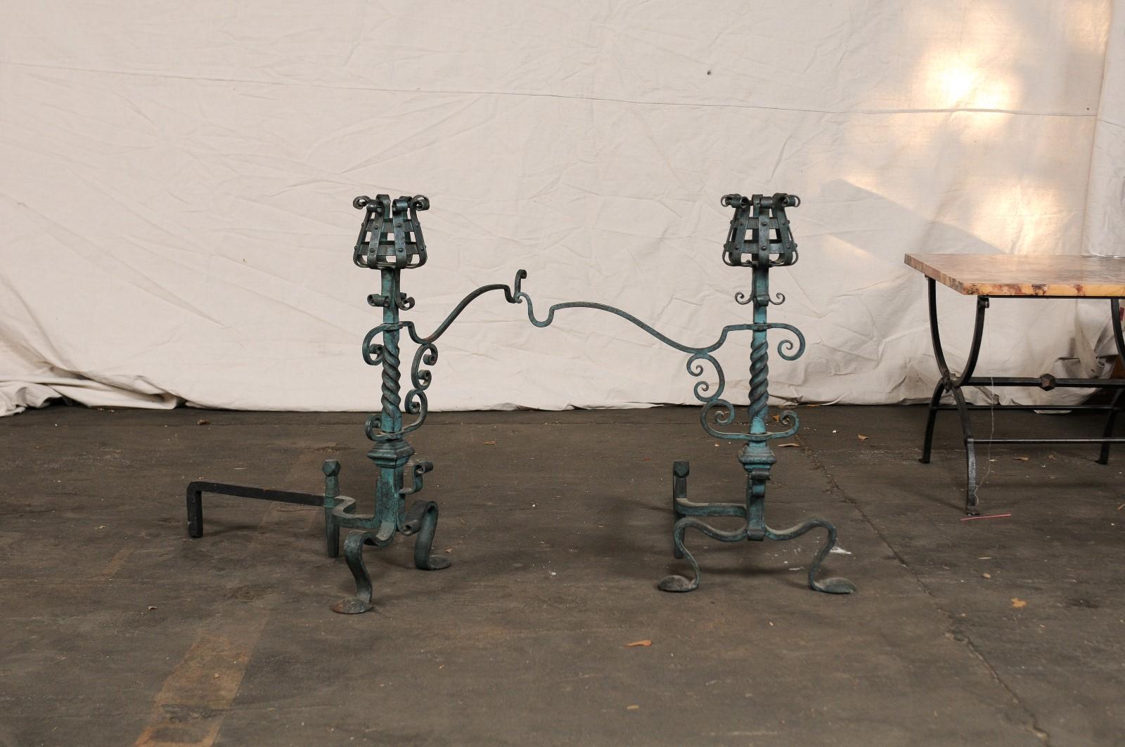 Pair of American iron andirons with patina finish and cooking arms, circa 1900.