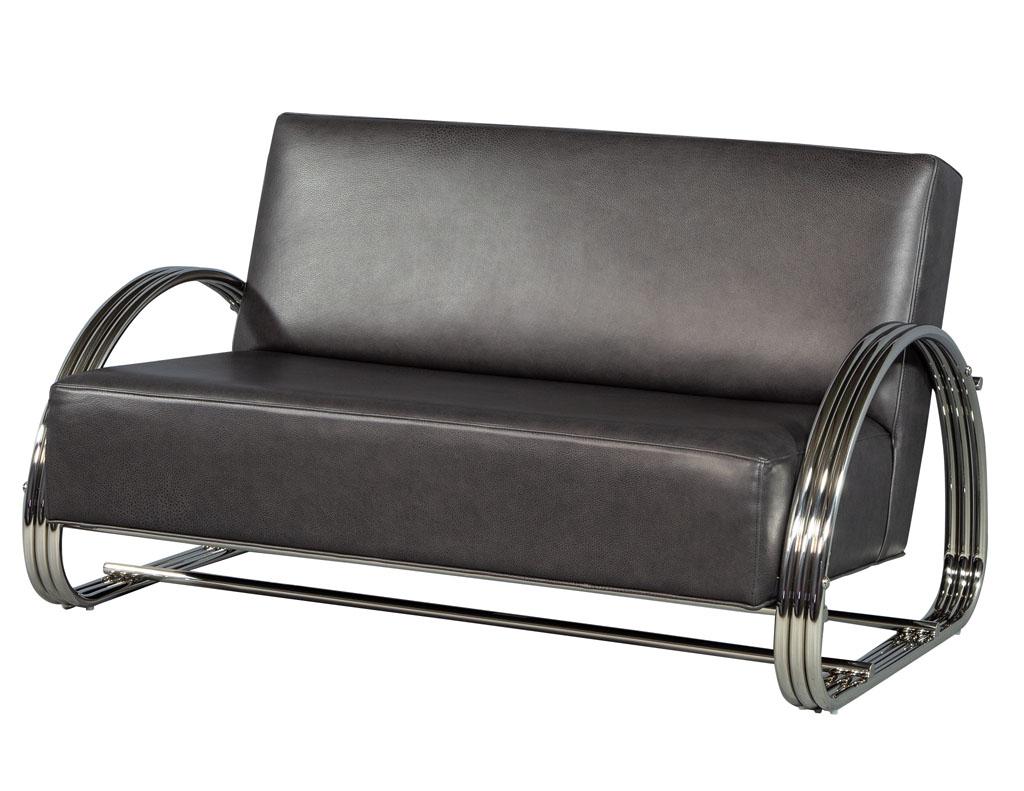 Pair of American made Mid-Century Modern inspired leather loveseat sofas. Modeled after the KEM Weber classic of the 1930s this lounge chair is elegant and extremely comfortable. The design of the frame features three bands of mirrored chrome and