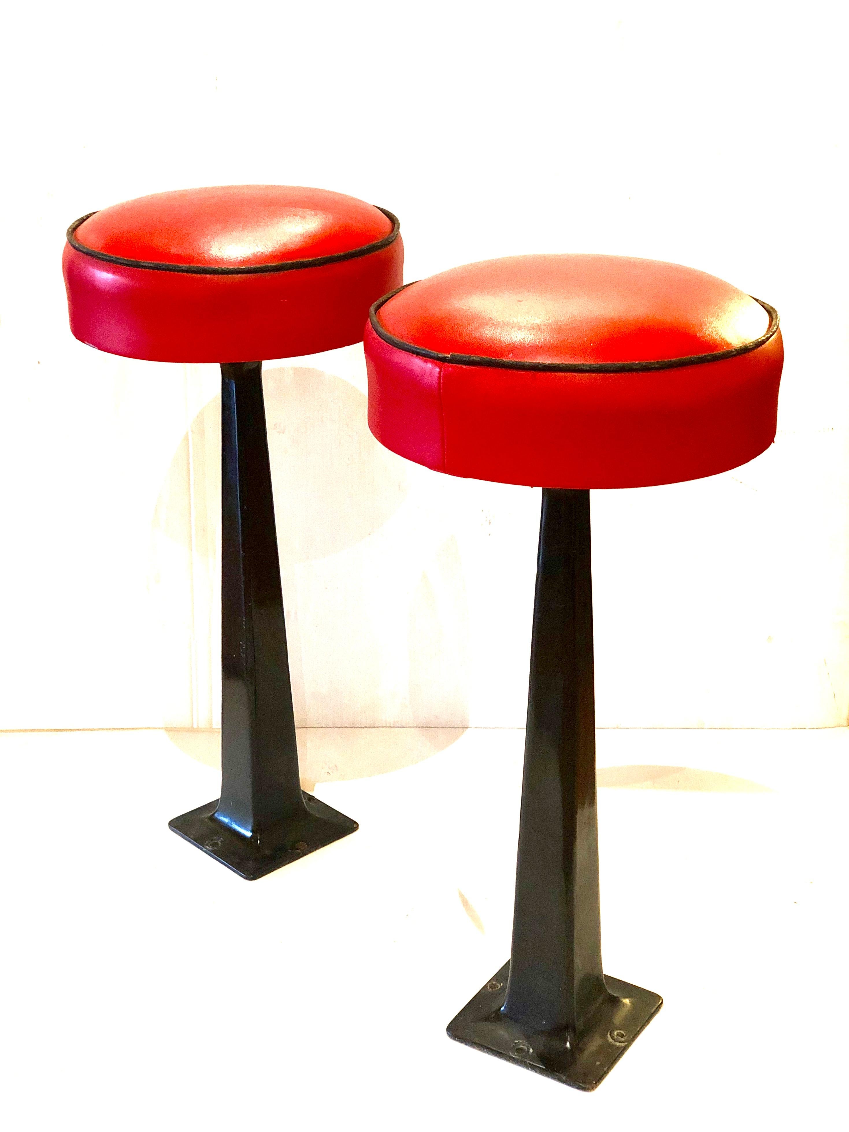 Nice pair of American midcentury swivel stools, Classic dinner stools with original Naugahyde in red with black pipping and solid steel base, they need to be bolder to the ground in very nice original condition.