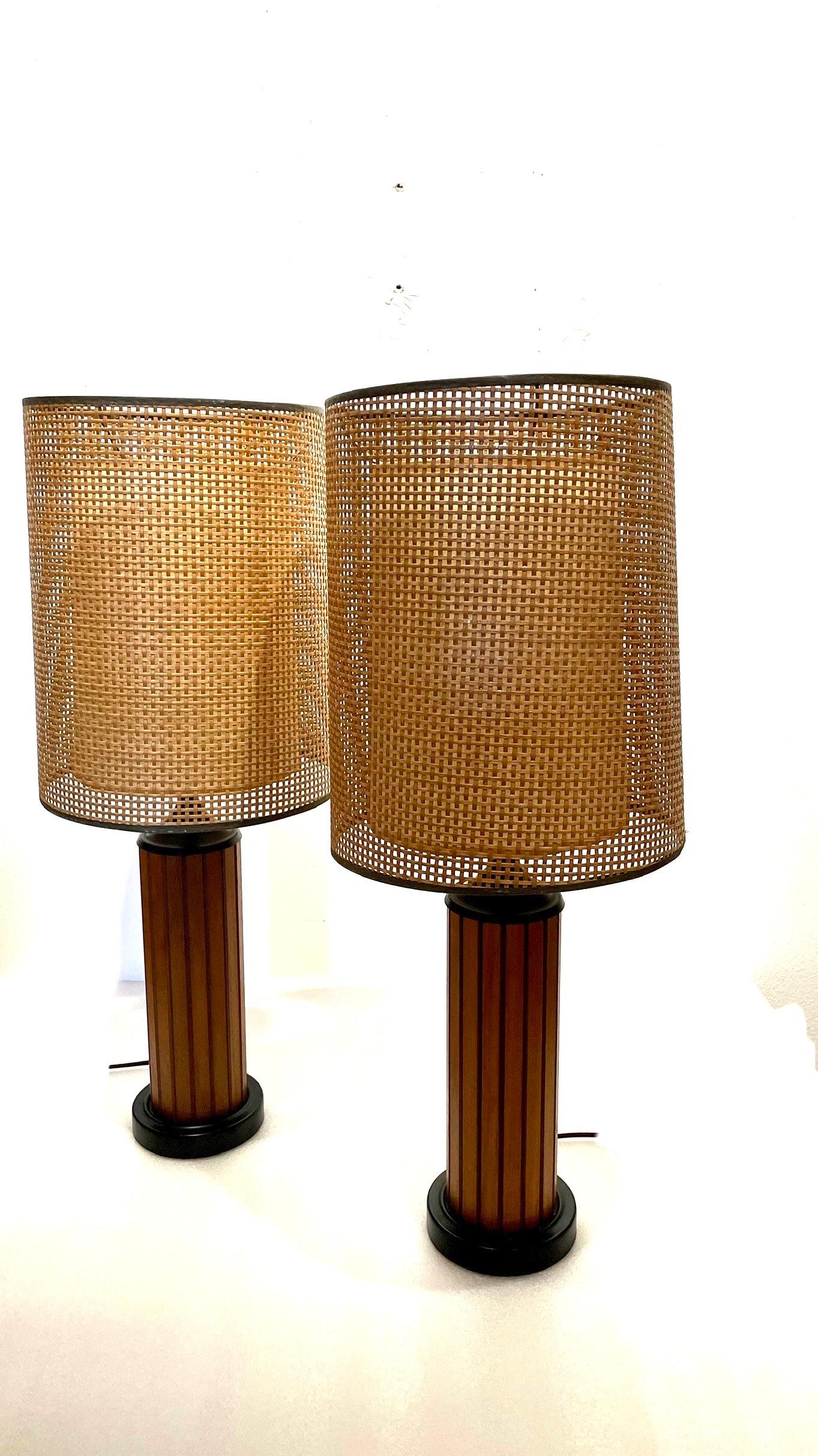 A classic American mid-century pair of table desk lamps, teak and metal base with original lampshades in cane and rice paper diffuser, in perfect working condition very light wear.