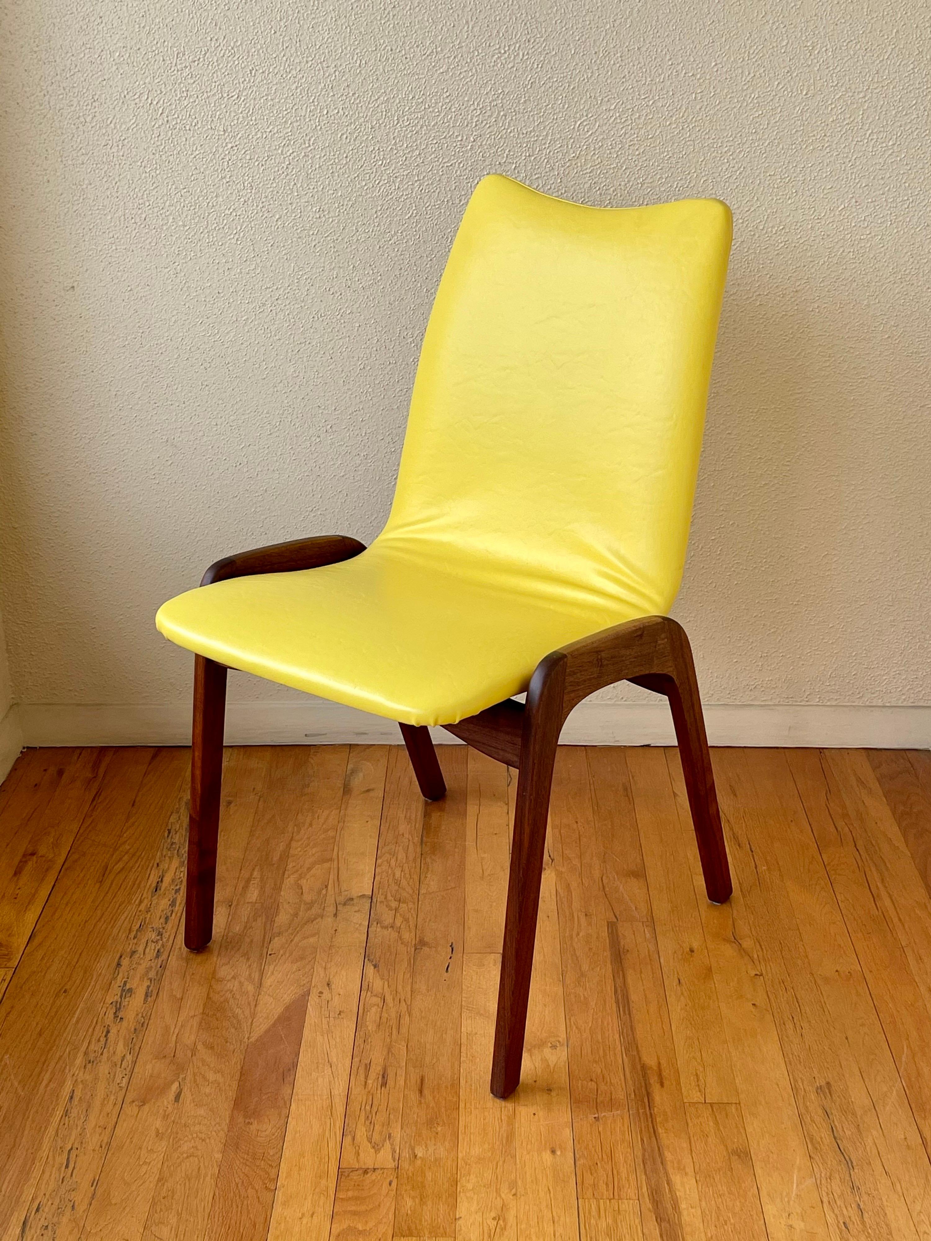 Cool pair of American Mid-Century Modern chairs by Chet Beardsley, circa 1970s awesome yellow original Naugahyde material solid walnut bases we have cleaned and refinished the bases these chairs, are solid and sturdy.
