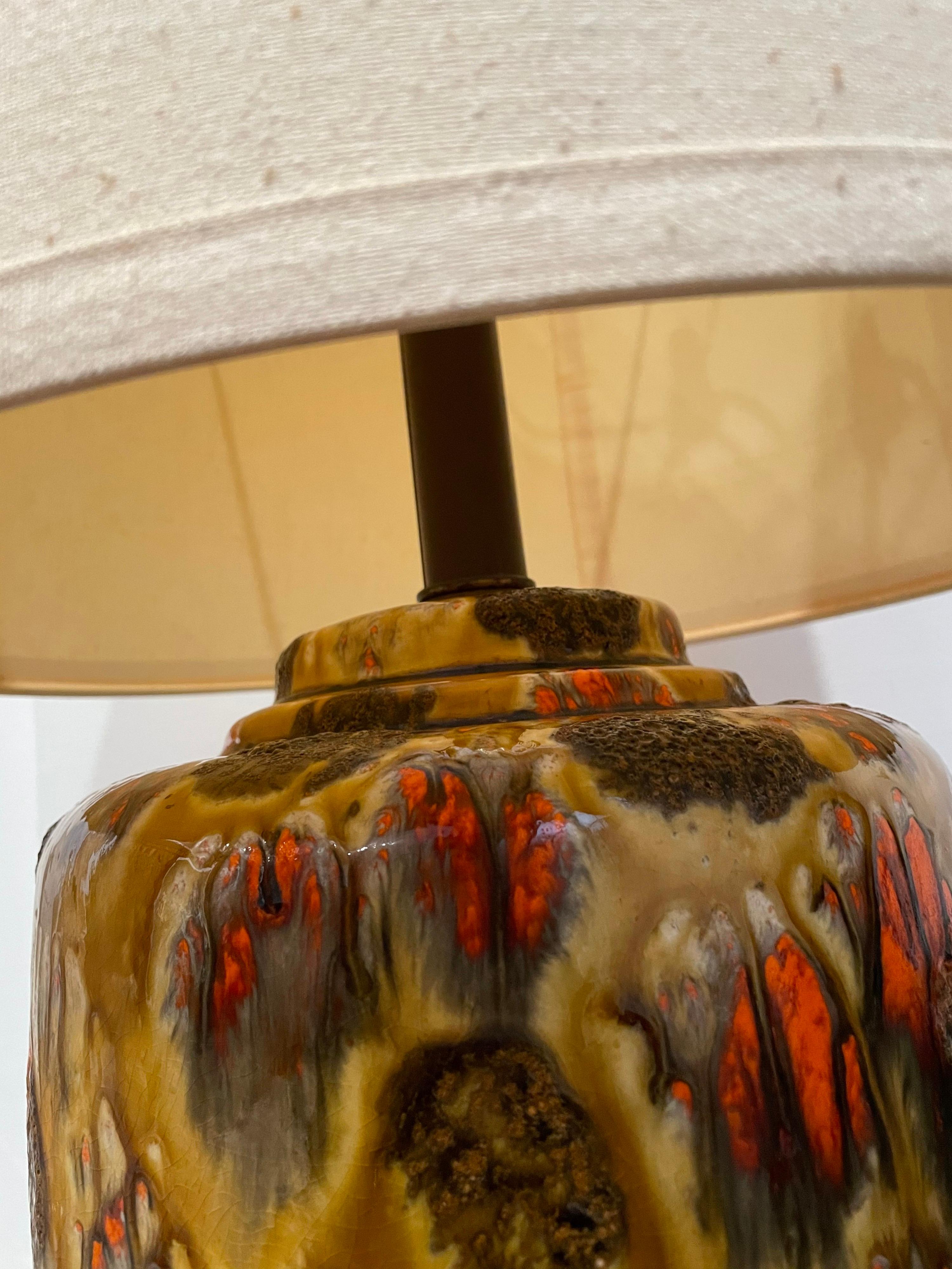 Beautiful pair of midcentury ceramic lava drip glazed table lamps. The pair includes original lampshades and together bring that MCM feel to your decor. Beautiful colors and glaze hard to find a matching set in this condition. And working.