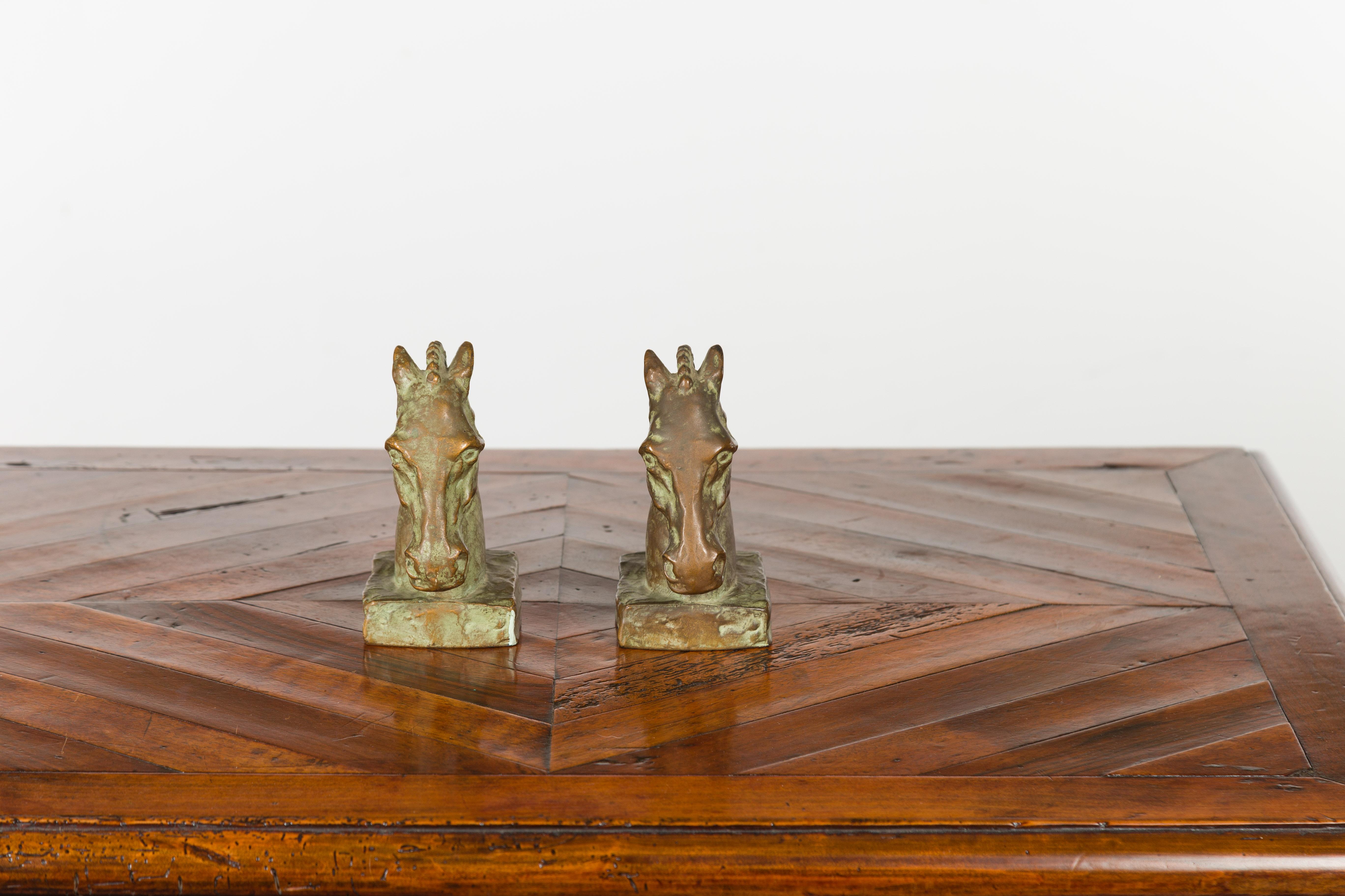 A pair of American Art Deco bronze McClelland Barclay horse head bookends from the mid 20th century, stamped. Made in the USA during the midcentury period, each of this pair of bronze sculptures depicts a horse head adorned with a stylized mane.
