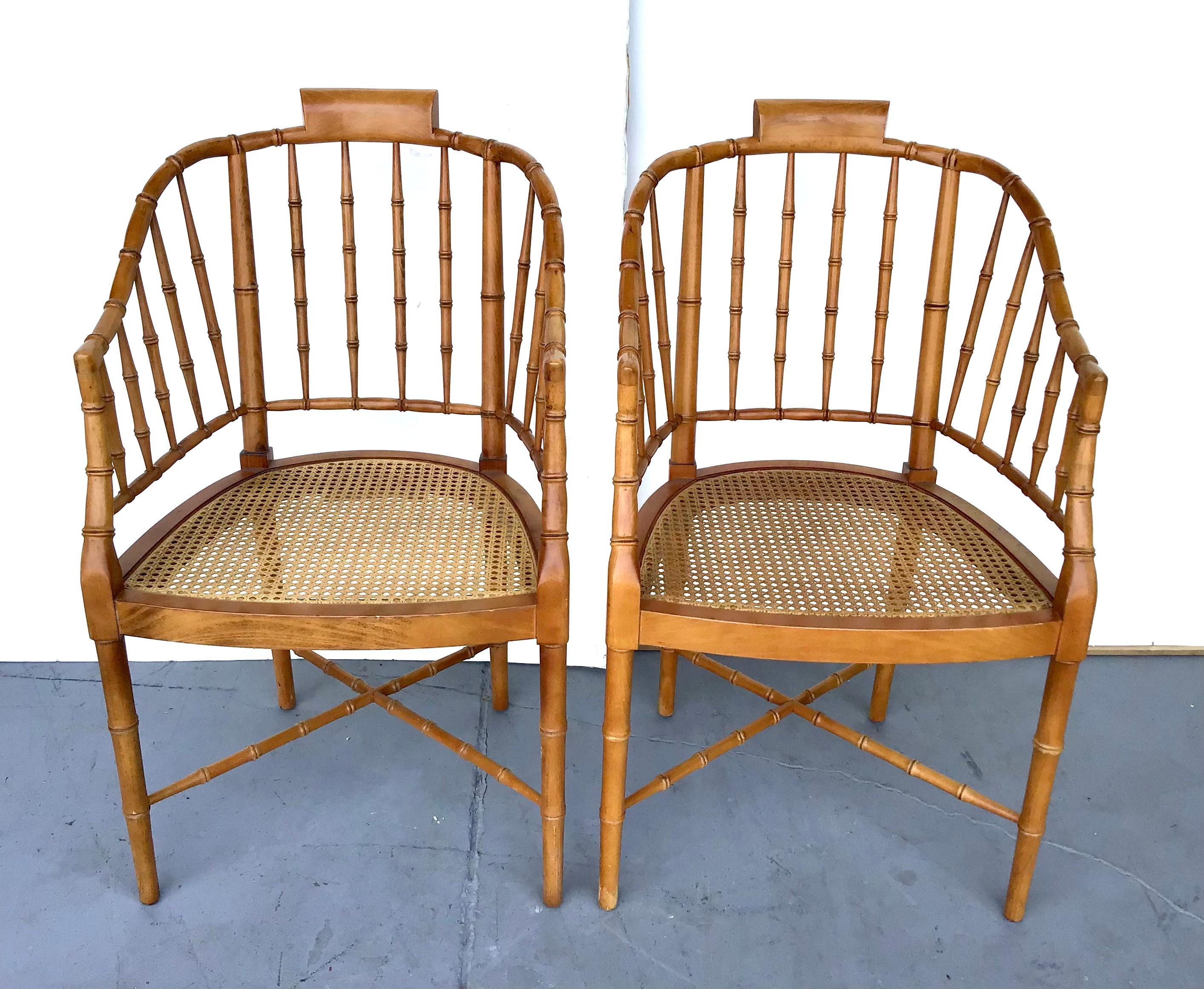 A pair of vintage Stickley Furniture faux-bamboo tub armchairs. Made of faux-bamboo, each of this pair of American chairs features a tub shaped back and curved arms resting on a cane seat. Each chair is raised on four slender legs, connected to one