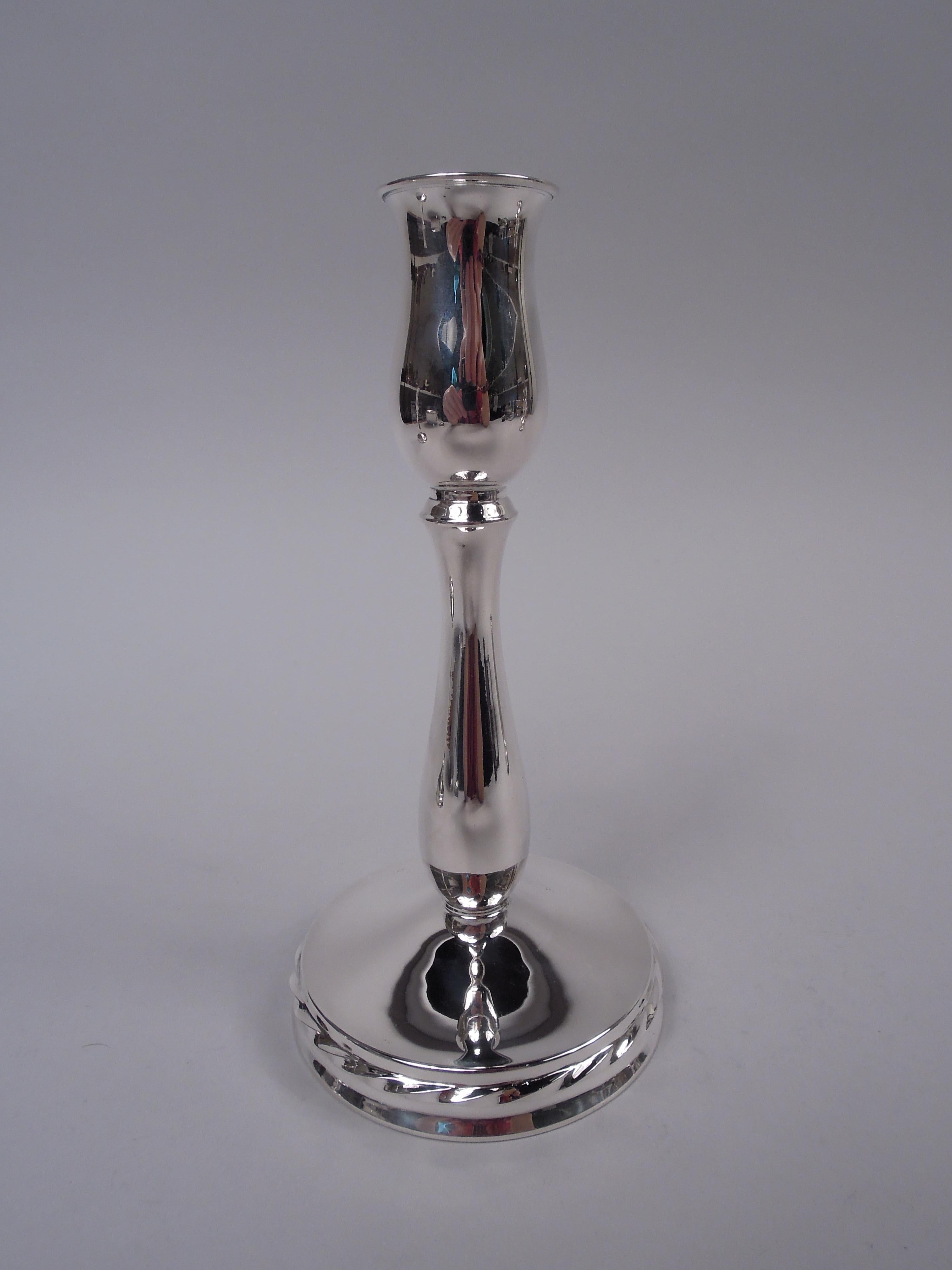 Pair of Modern Georgian sterling silver candlesticks. Made by Towle Silversmiths in Newburyport, Mass., ca 1940. Each: Elongated baluster socket with flat rim on baluster shaft. Raised round foot with cabled band wrapped around sides. Fully marked