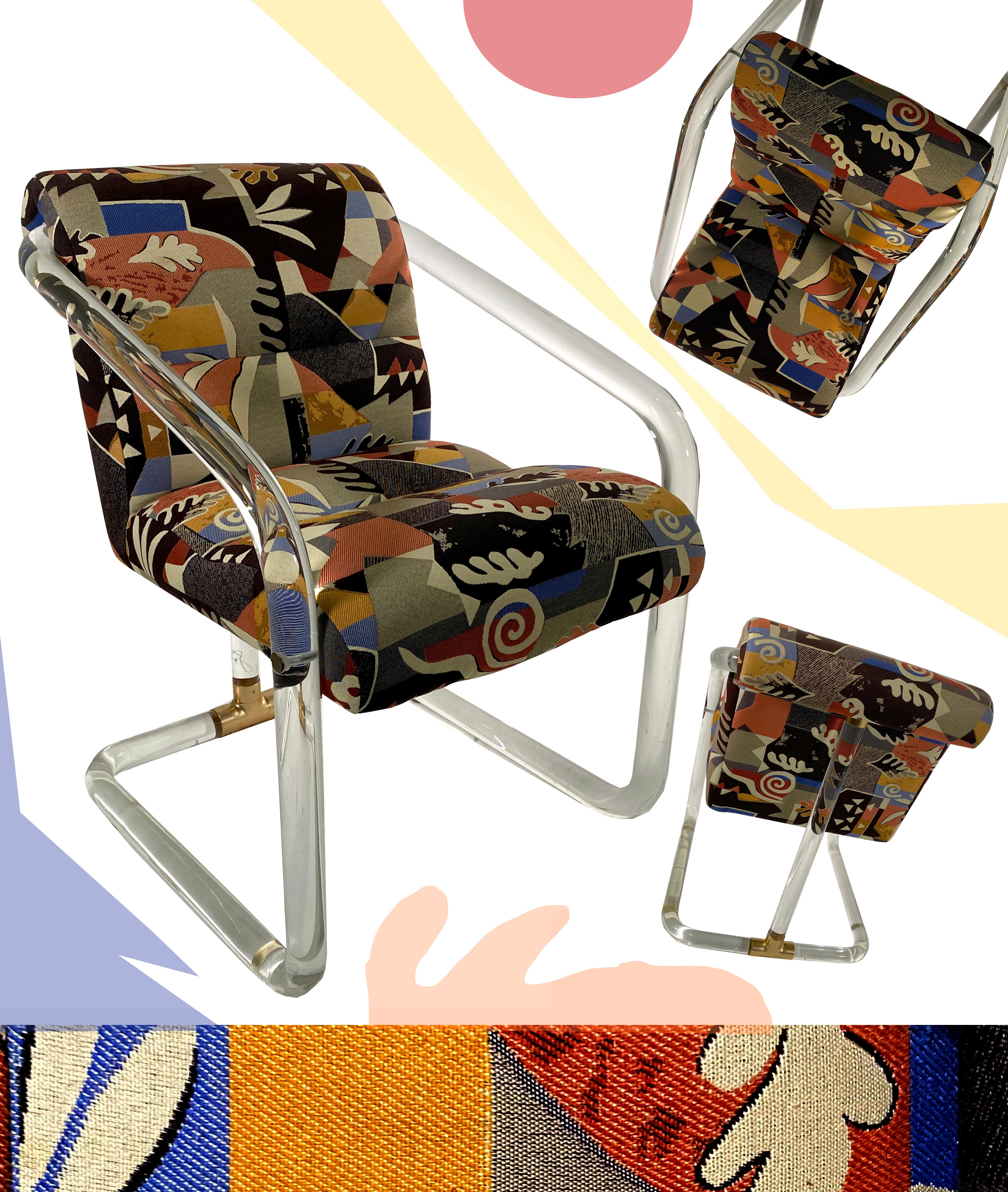 A beautiful pair of chairs, by Lion in Frost, with fabric derived by Henri Mattise. The chairs are sculptural with lucite tubes for arms/supports down the leg, the connections done in brass. The fabric is a rich upholstery with shapes and colors