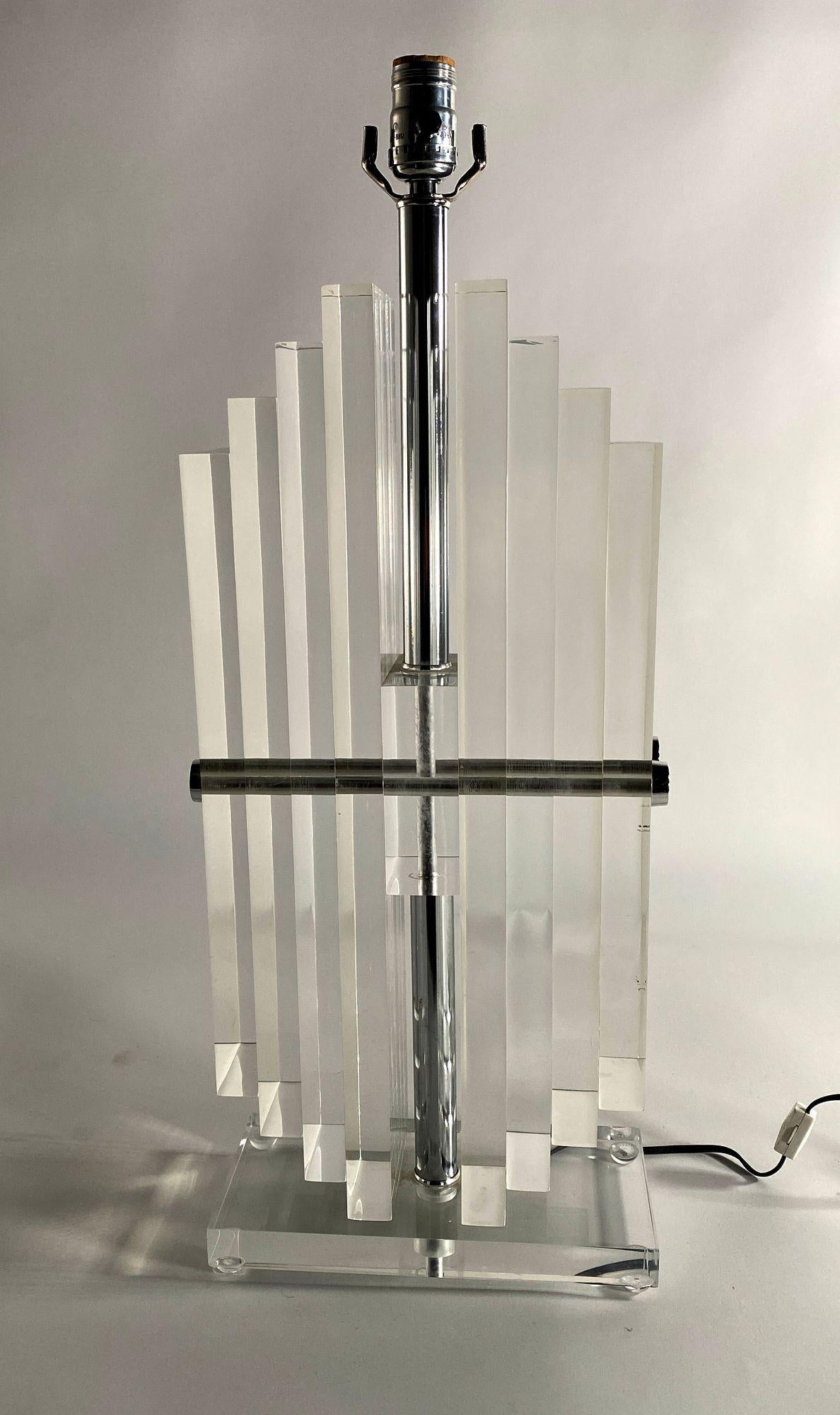 American modern stacked lucite lamps by Karl Springer. Stacked vertical shapes of lucite in staggered patterns sitting upon a lucite base.
