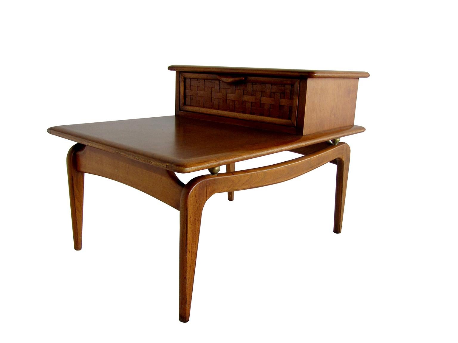 The table base with a box cabinet and woven front drawer, on curved scissor legs.