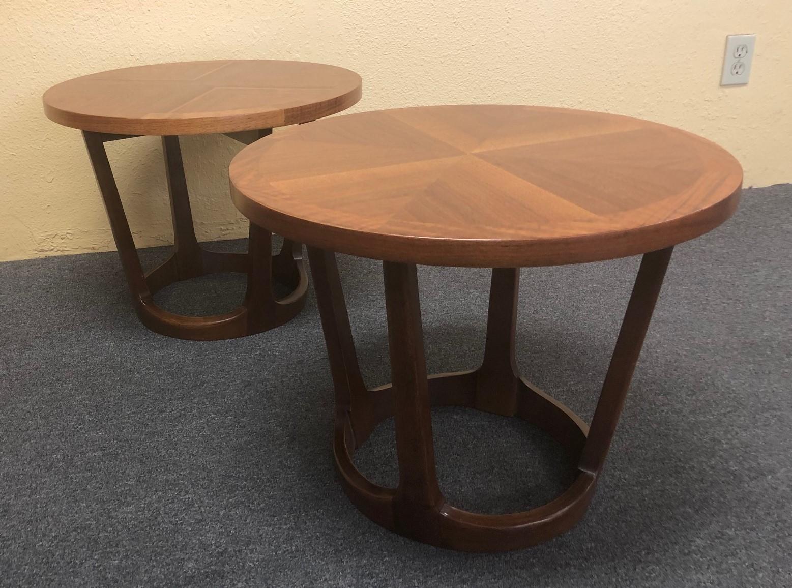 Pair of American modern walnut end / side tables by Lane Furniture, circa 1960s. Beautiful craftsmanship and sturdy construction on these round tables with tapered support beams. The tabletop has been professionally refinished and shows an