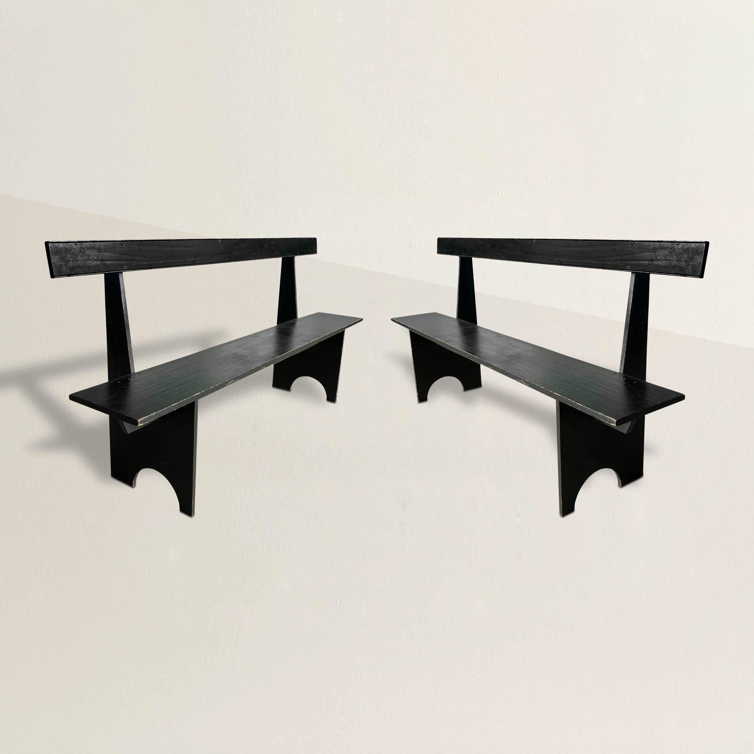 A chic pair of mid-20th century American modernist Shaker-inspired pine benches with striking silhouette that bend seamlessly into any style interior. Painted black with signs of wear from over 50 years of use. Perfect in your dining room, down a