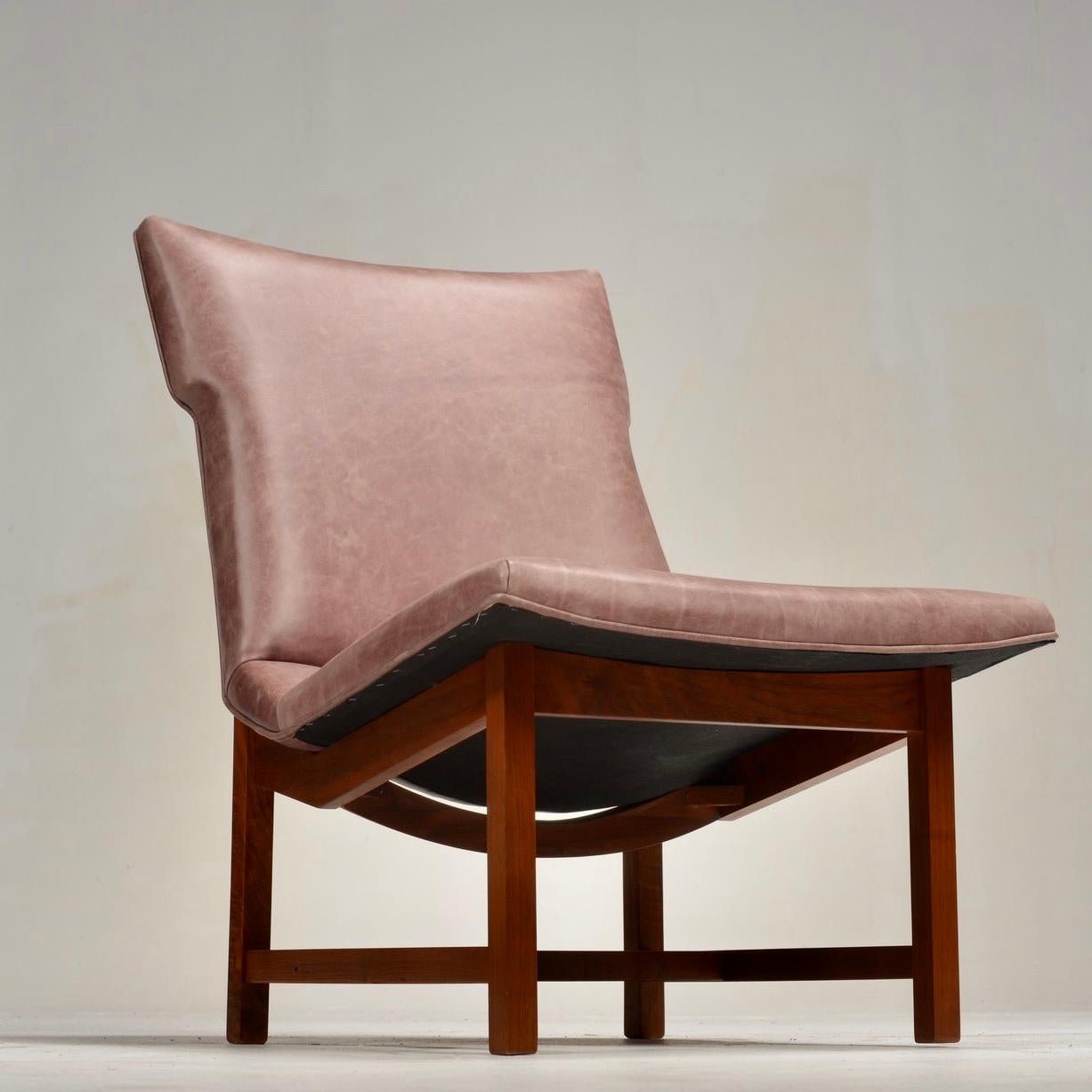 Set of two (2) Mid-century modern lounge chairs in the style of Jens Risom circa 1960s–70s. Featuring a sculpted seat and backrest upholstered in leather, supported on a solid Walnut base with cross-braced legs. Willing to separate the pair and sell