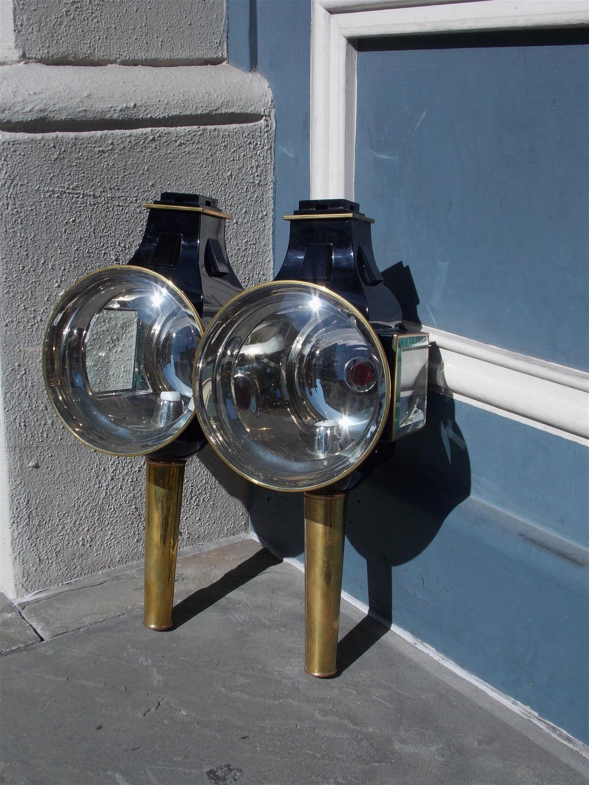 Pair of American nickel silver and brass enameled iron coach lanterns with the original circular and side lamp beveled glass. Lanterns are candle powered but can be converted to electricity or gas at additional cost, Mid-19th century.