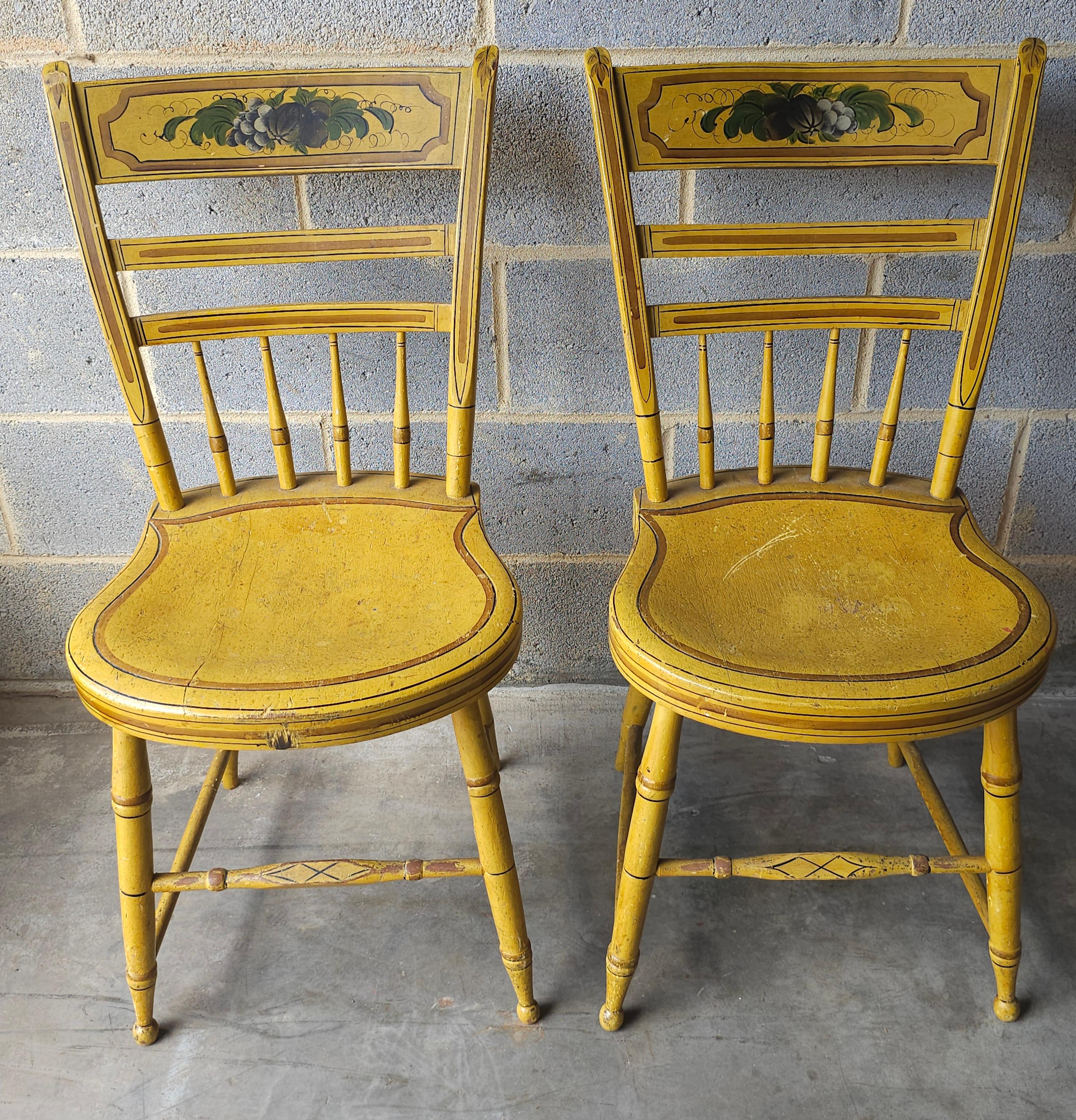 Pareja de sillas americanas pintadas y decoradas de color amarillo, cada una con la marca 