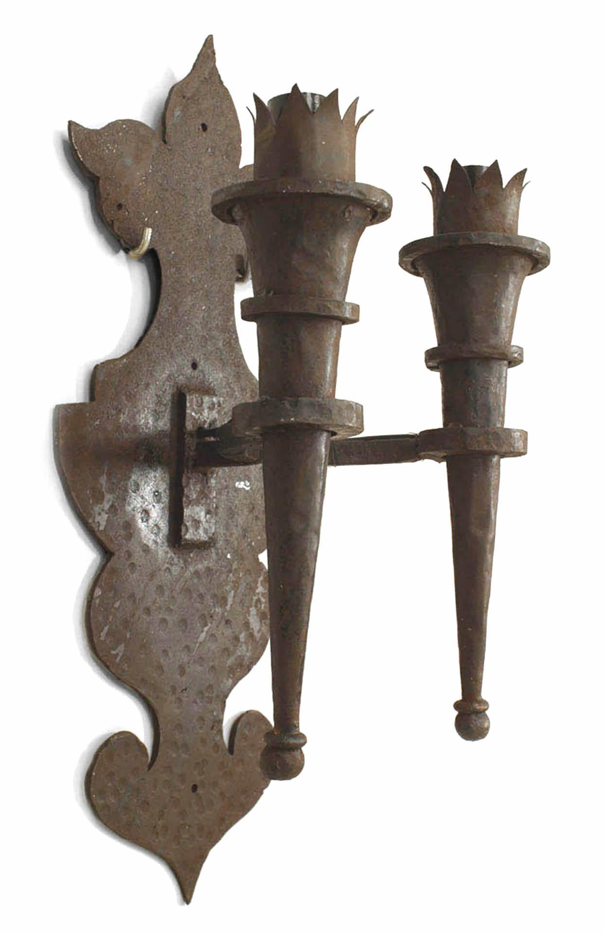 Pair of American Renaissance Revival-style (20th Century) wrought iron wall sconces with two torch design arms and shaped backplate. (PRICED AS Pair)
