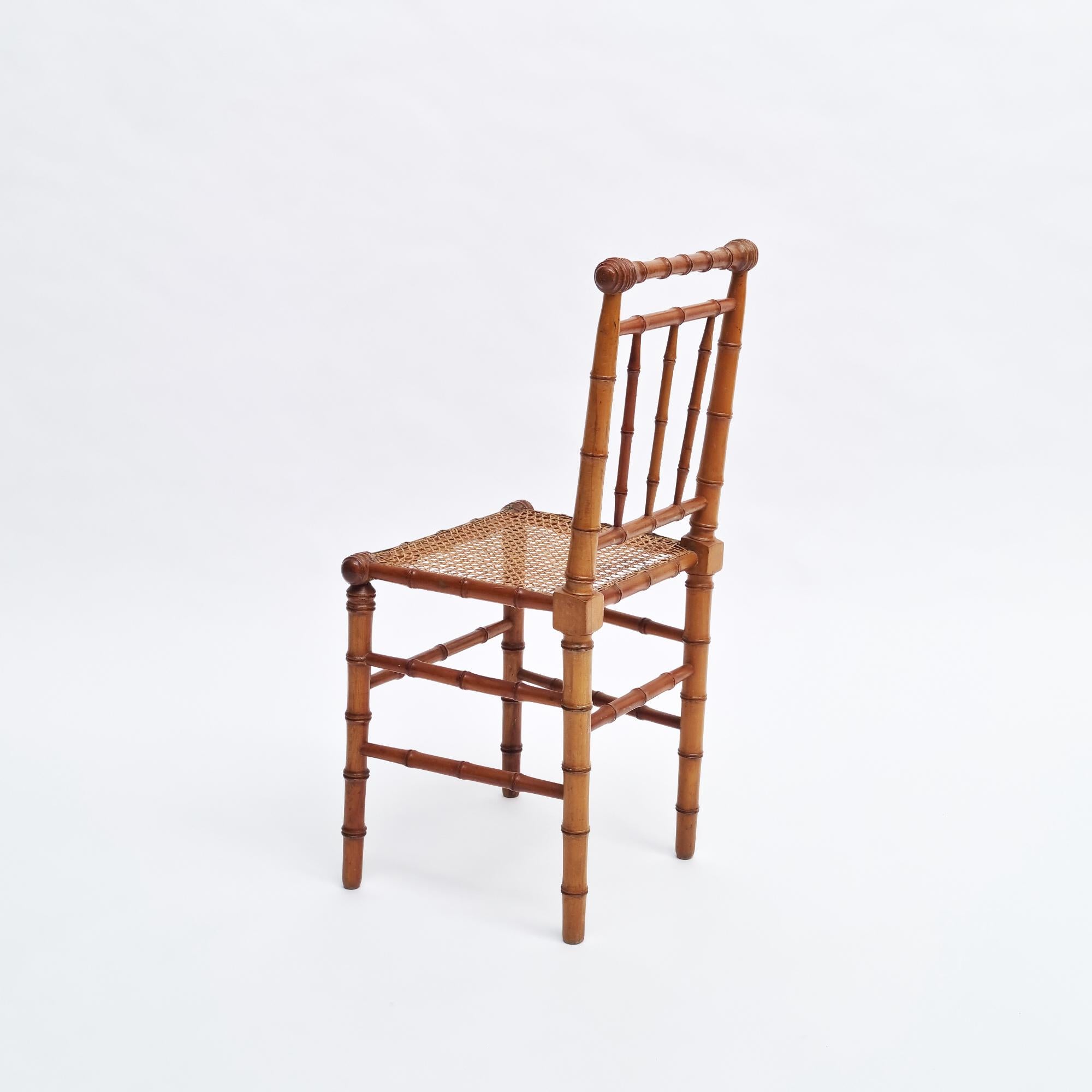 Coppia di poltroncine vittoriane americane in finto bambù con sedili in canna, risalenti al 1880 circa, offerte nelle loro condizioni originali. Queste sedie sono caratterizzate da splendidi design e dettagli intricati, che riflettono l'eleganza