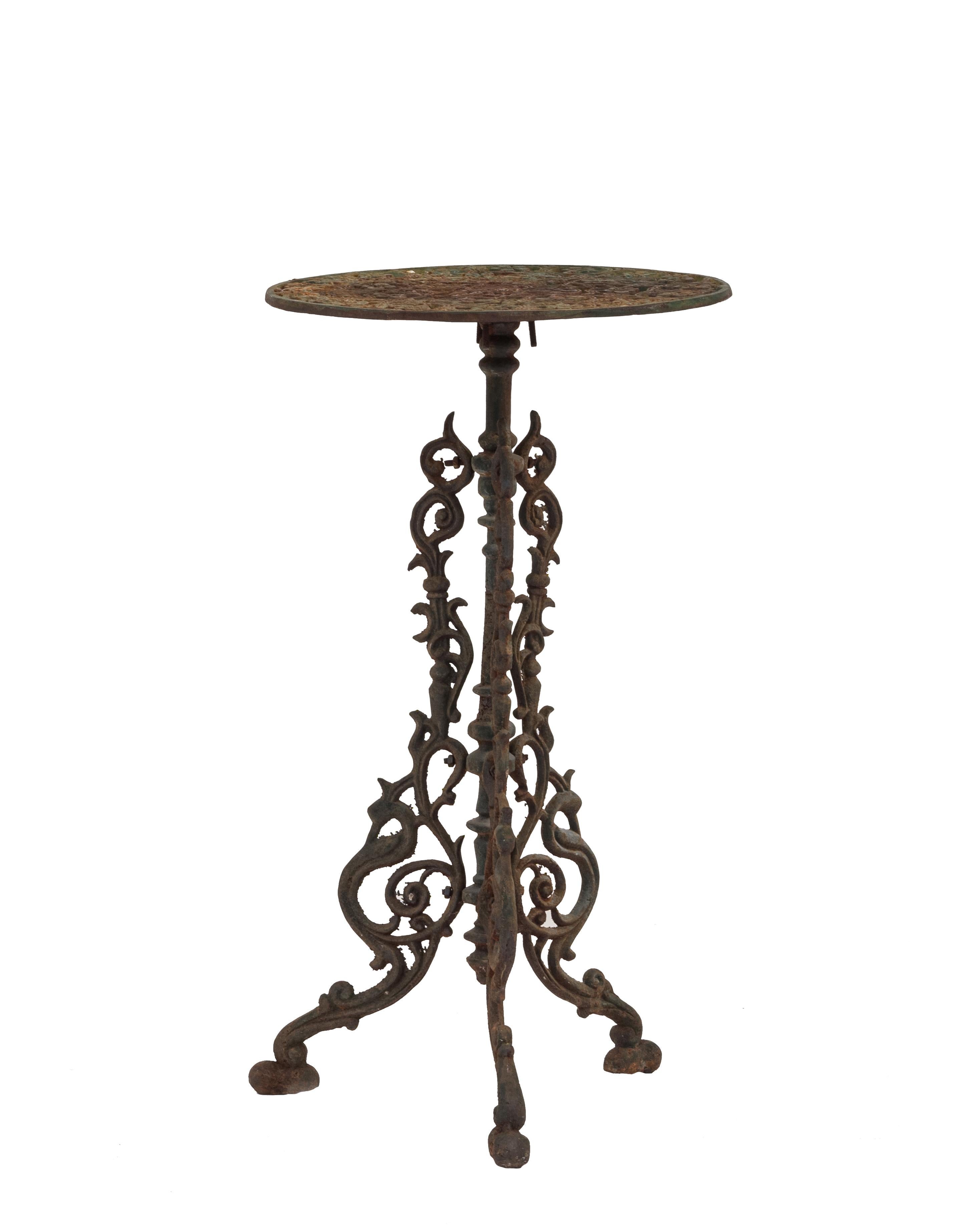Pair of American Victorian outdoor iron end / side tables with round filigree tops supported on a pedestal base with 3 filigree legs and having traces of original green paint (priced as pair).    
  