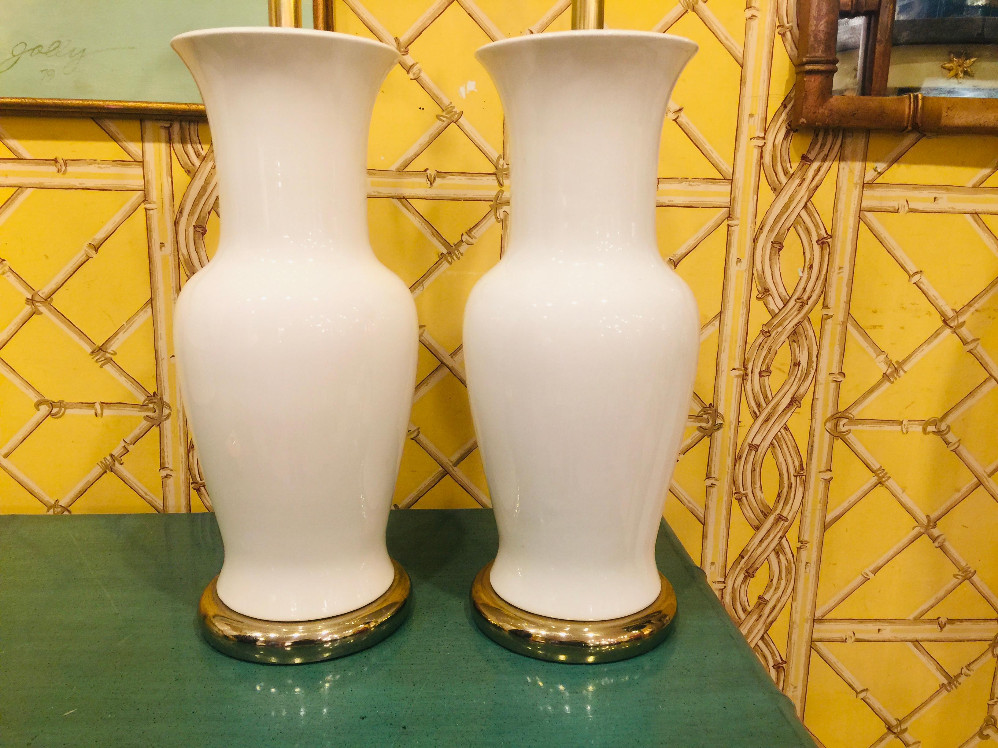 Pair of American midcentury white porcelain vase lamps on brass bases.