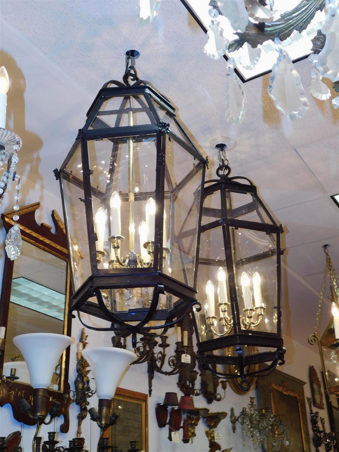 Pair of American wrought iron and brass dome shaped hanging lanterns with decorative floral corner medallions, scroll work, and circular ring finials. Early 19th Century. Pair were originally candle powered and have been electrified with a six light