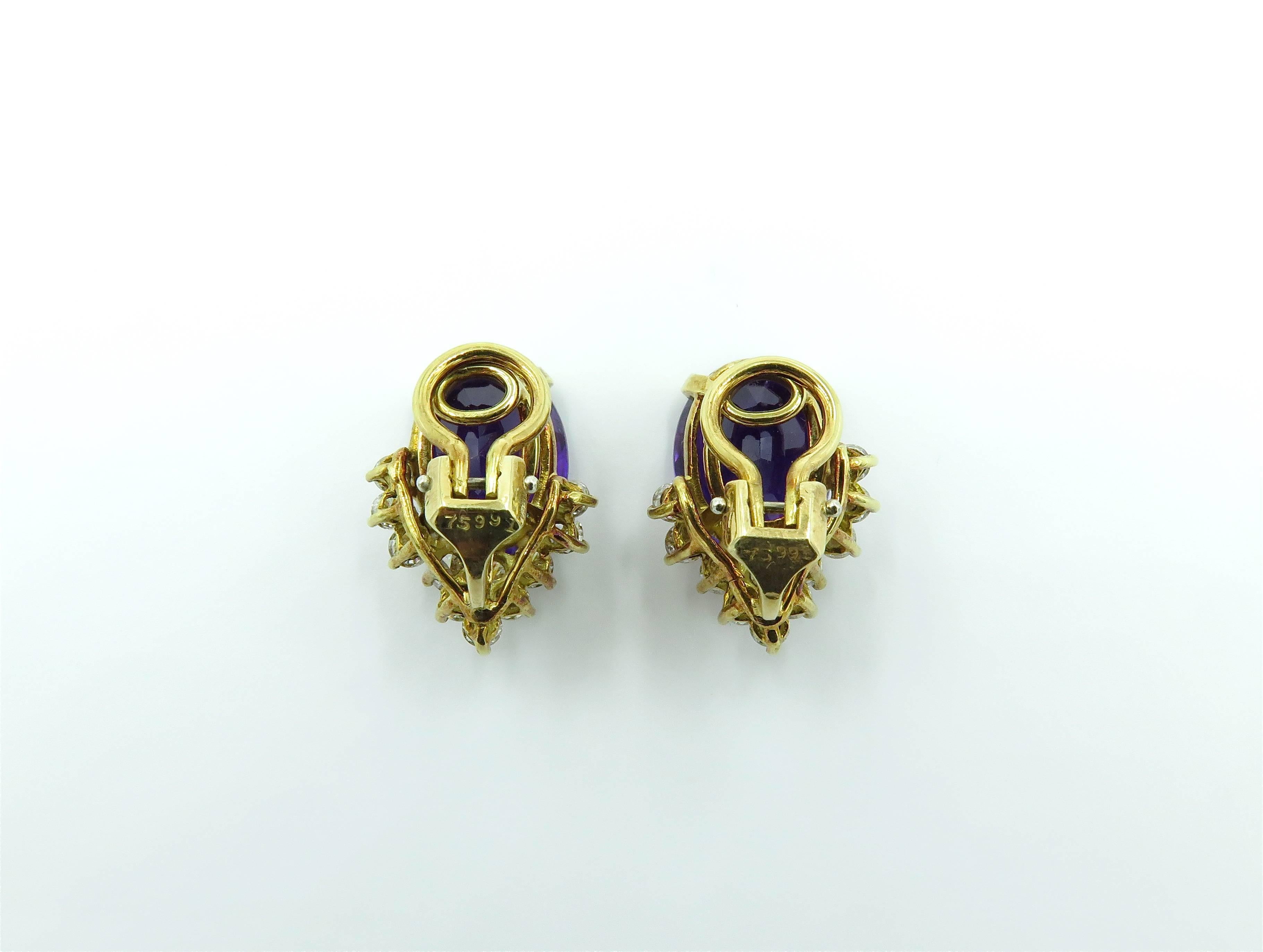 A pair of 18 karat yellow gold, amethyst and diamond earrings. Each set with an oval cut amethyst weighing approximately 5.80 carets, enhanced by a cluster of circular cut diamonds. Twenty two (22) diamonds weigh approximately 1.10 carats. Length is