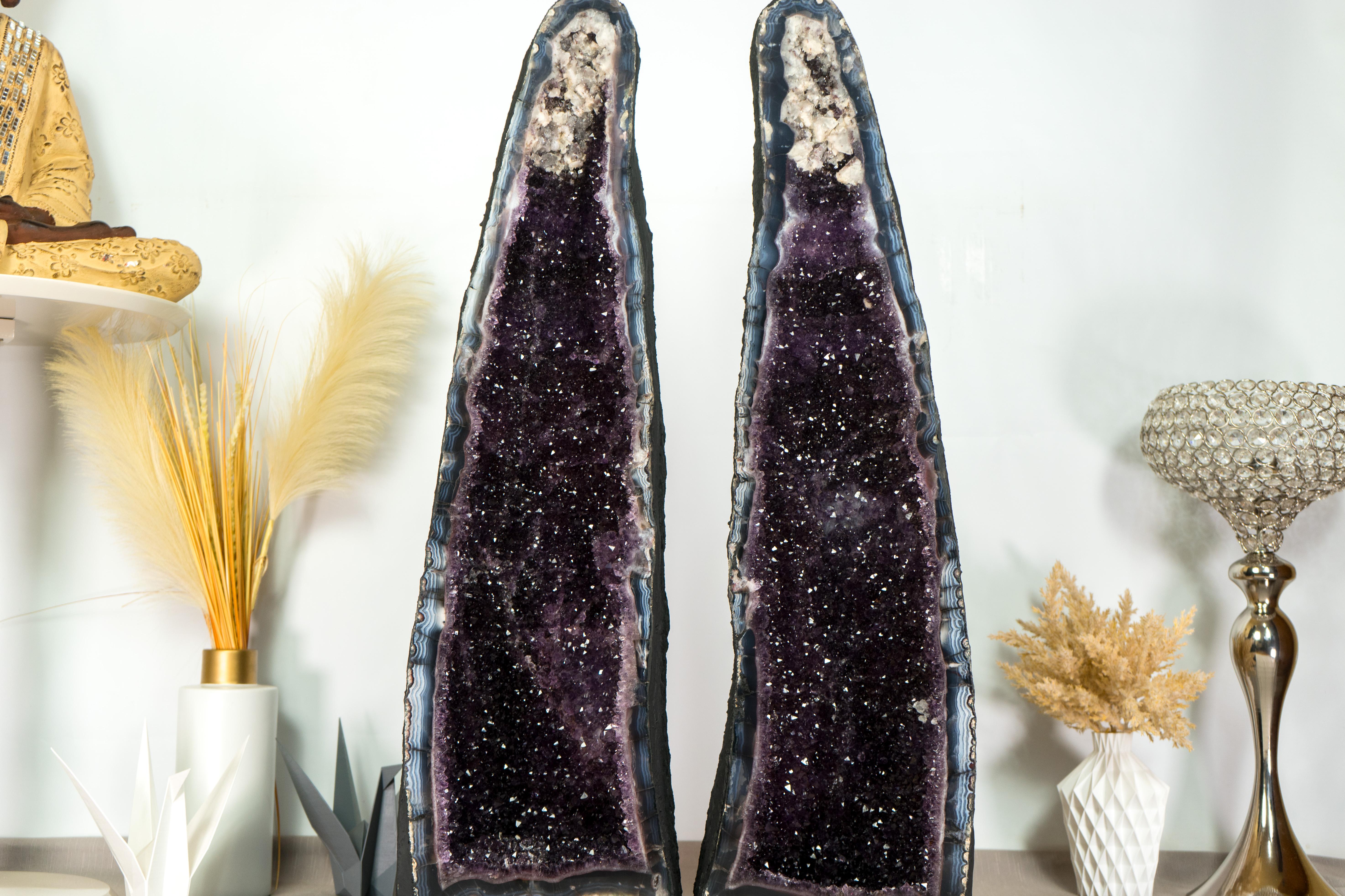 Breathtaking and beautiful, this pair of Agate with Amethyst Geodes feature spectacular blue-banded agate lines and rare, stunning aesthetics. Enhanced by shiny Amethyst that perfectly complements its beauty, this all-natural geode artwork is