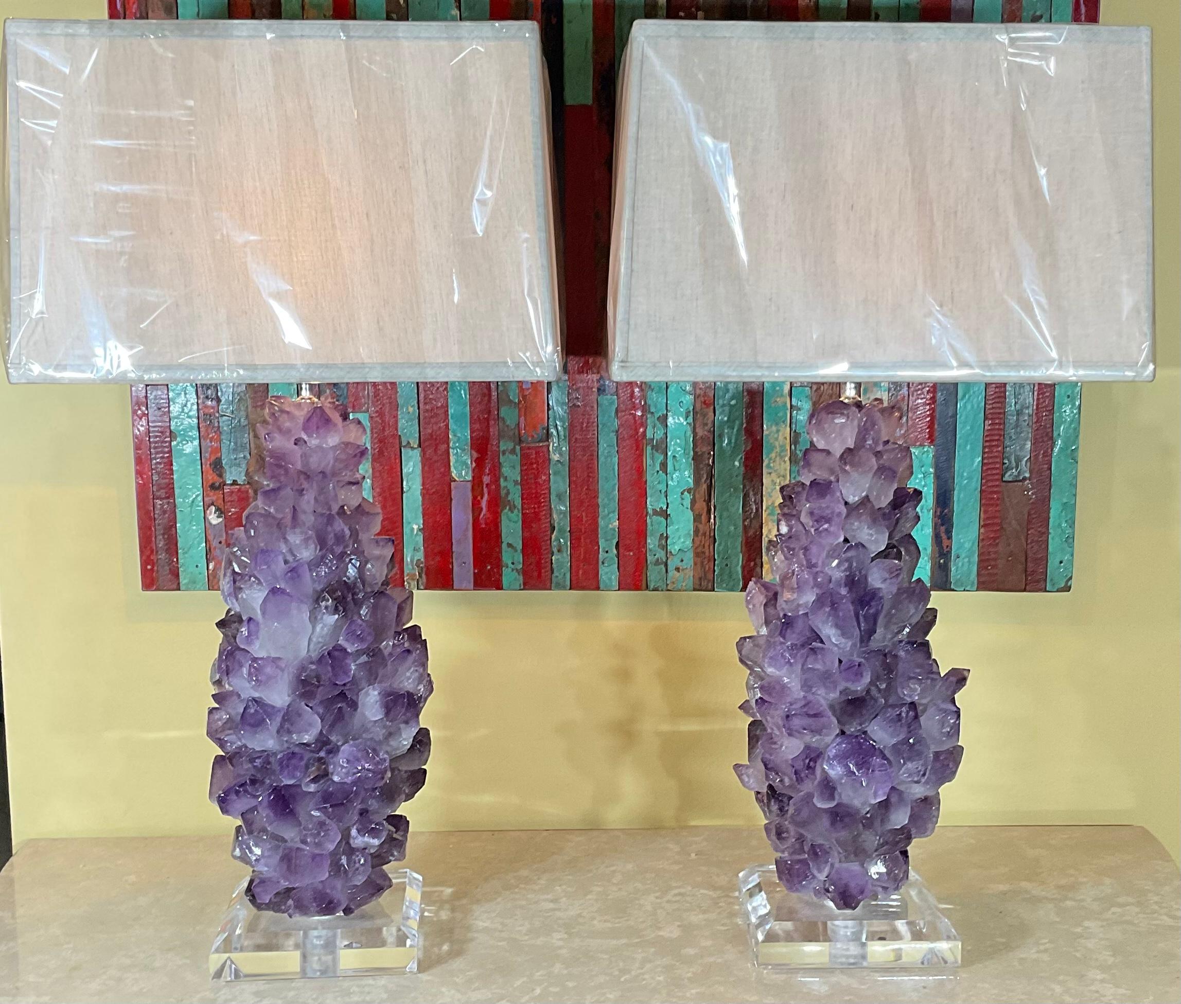 Fantastic one of a kind pair of lamps made of amethyst crystal quartz, mounted on a beveled lucite base 
Wired and ready to light.
Lucite base size: 7” x 7” x 1.5
Lamp shades are not included.