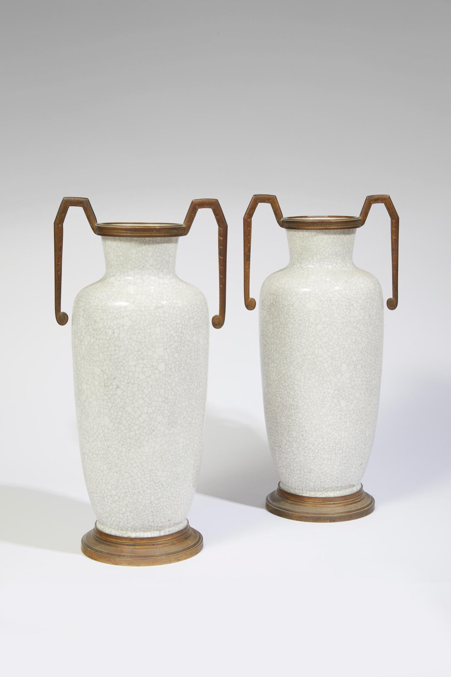 Pair of white cracked enameled porcelain amphorae vases with a patinated, bronze neck, handles and base.
Numbered 723, one signed and with a medallion with the monogram, LD, Made in France.