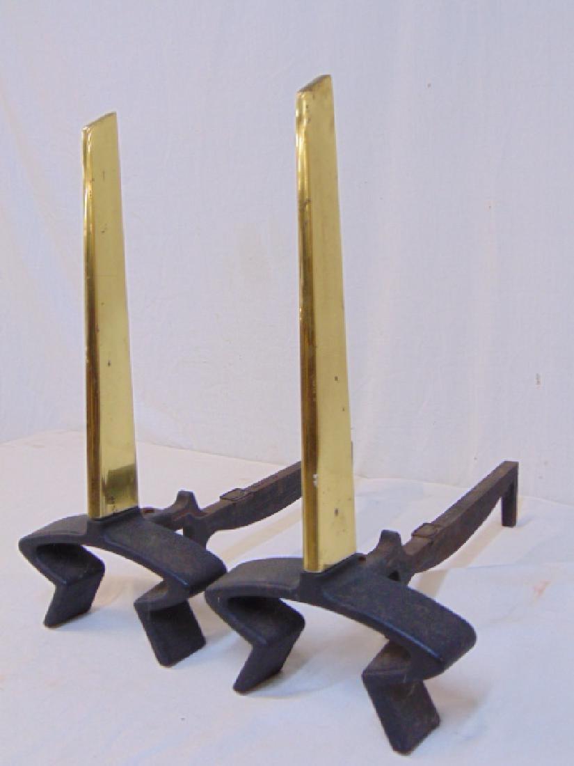 A pair of andirons designed by Donald Deskey for Bennett, USA, circa 1950. Brass design with and iron supports.