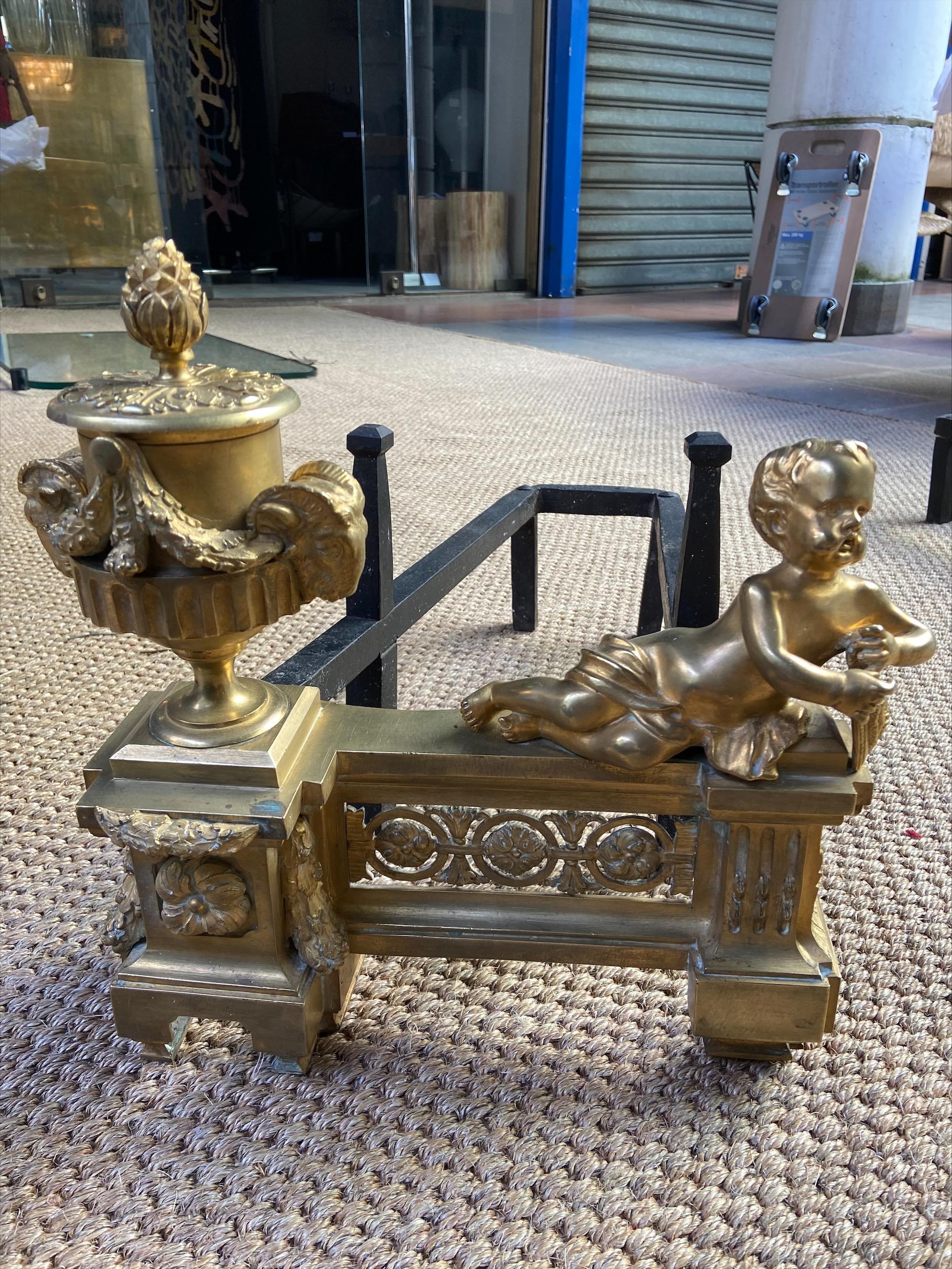 Pair of andirons
Gilt bronze and wrought iron

Measures: H 33 x W 32x D 56 cm

Late 18th century

An andiron is a fireplace accessory. It is a piece of wood or metal often placed in pairs in a fireplace or hearth and used to support the logs, so