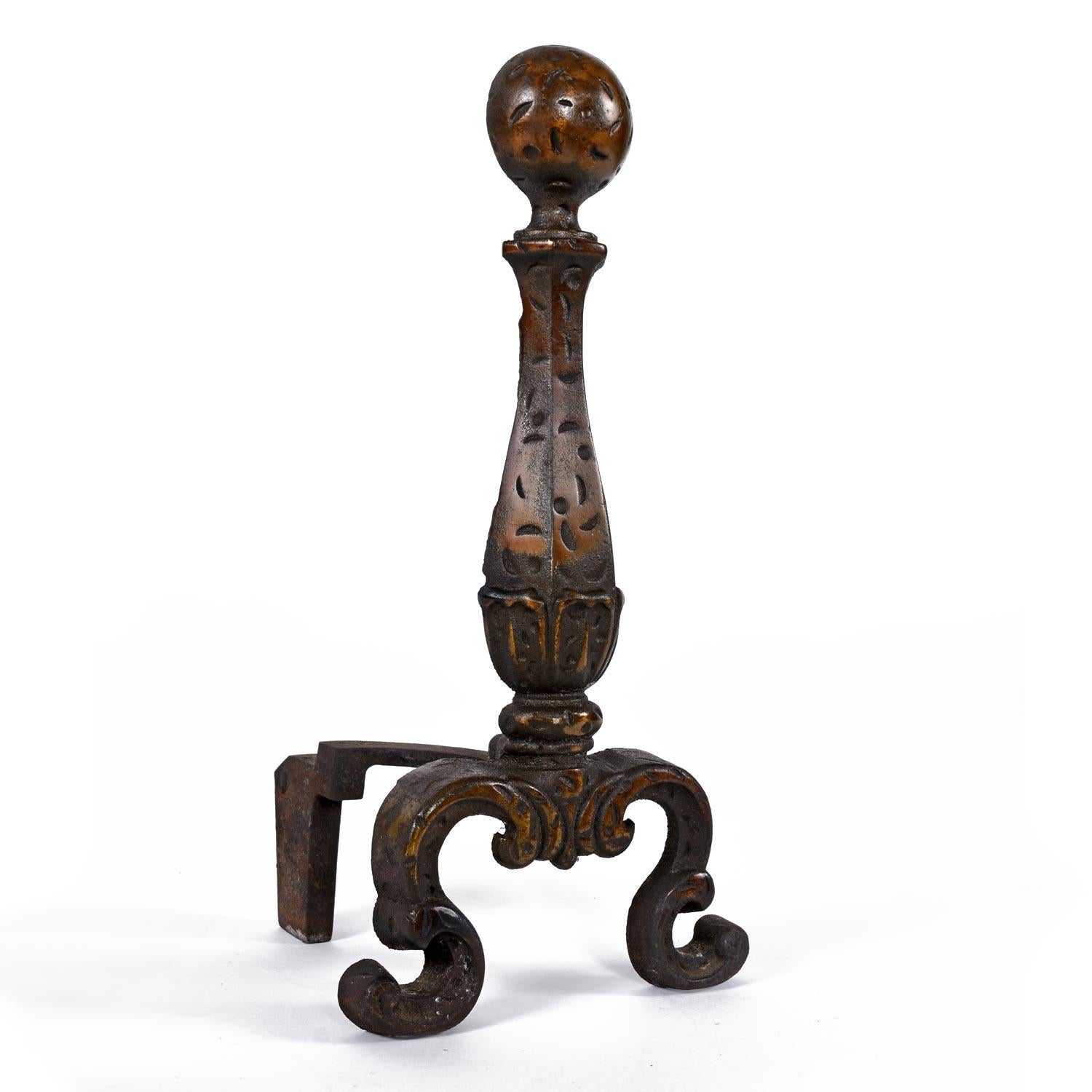 Handsome pair of mid-20th Century hammered texture andirons. The andirons are in traditional form with the hourglass body balanced on elegantly curved legs. A round cannonball shape crowns the andirons. The wrought iron andirons have a decorative