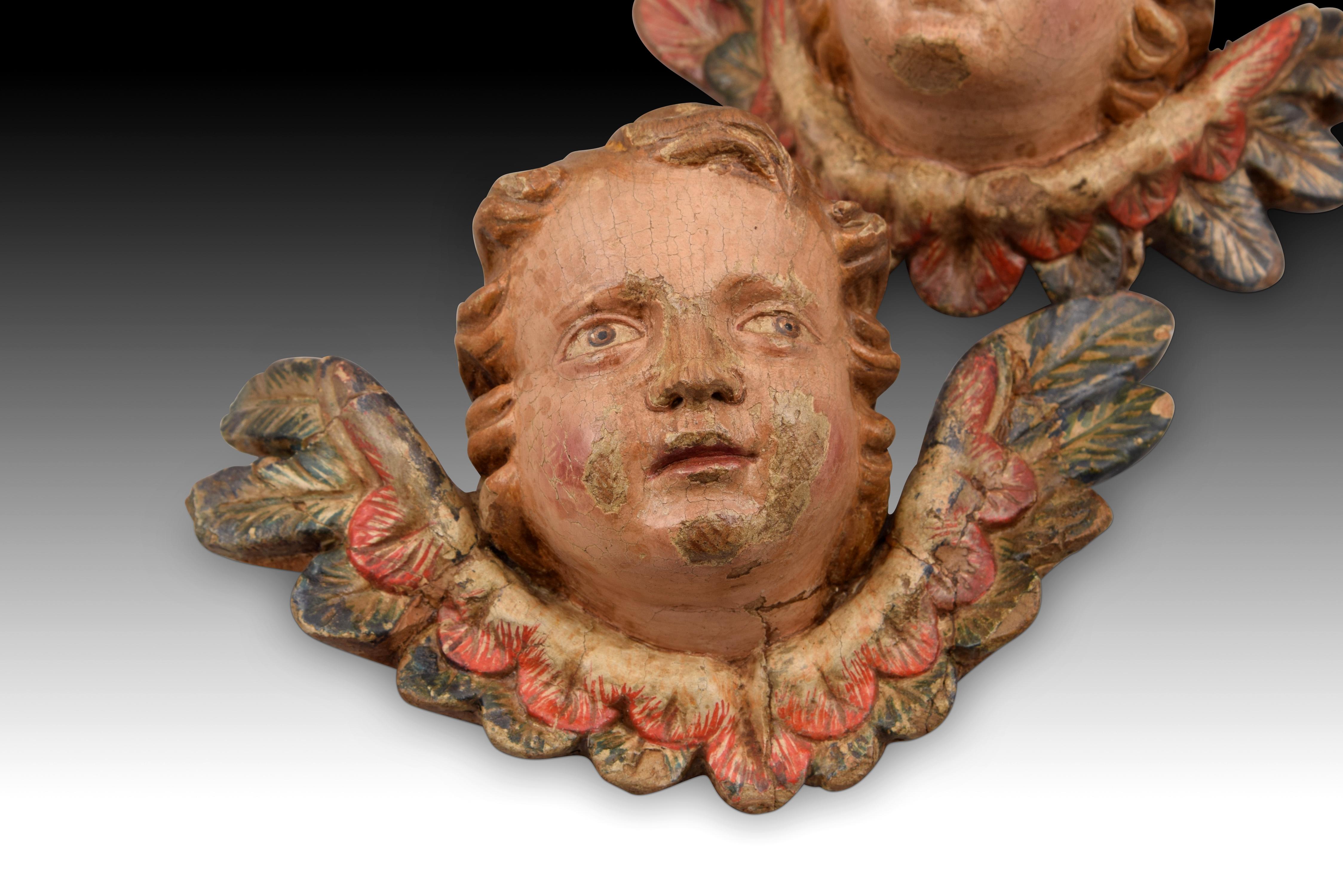 Pair of angel heads. Carved and polychrome wood. Spanish school, 18th century. 
Pair of children's heads, from which a pair of wings emerge in each case, made of carved and polychrome wood. This type of sculpture was common in the Spanish school