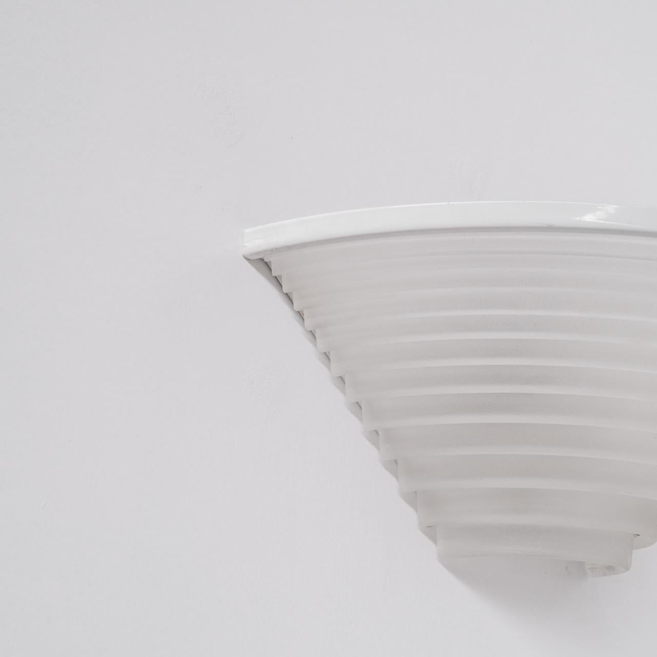 Ein Paar Wandleuchten mit Metallrahmen und undurchsichtigen, abgestuften Glasschirmen.

Italien, ca. 1970er Jahre.

Von dem geschätzten Designer Angelo Mangiarotti für Artemide. Modell 