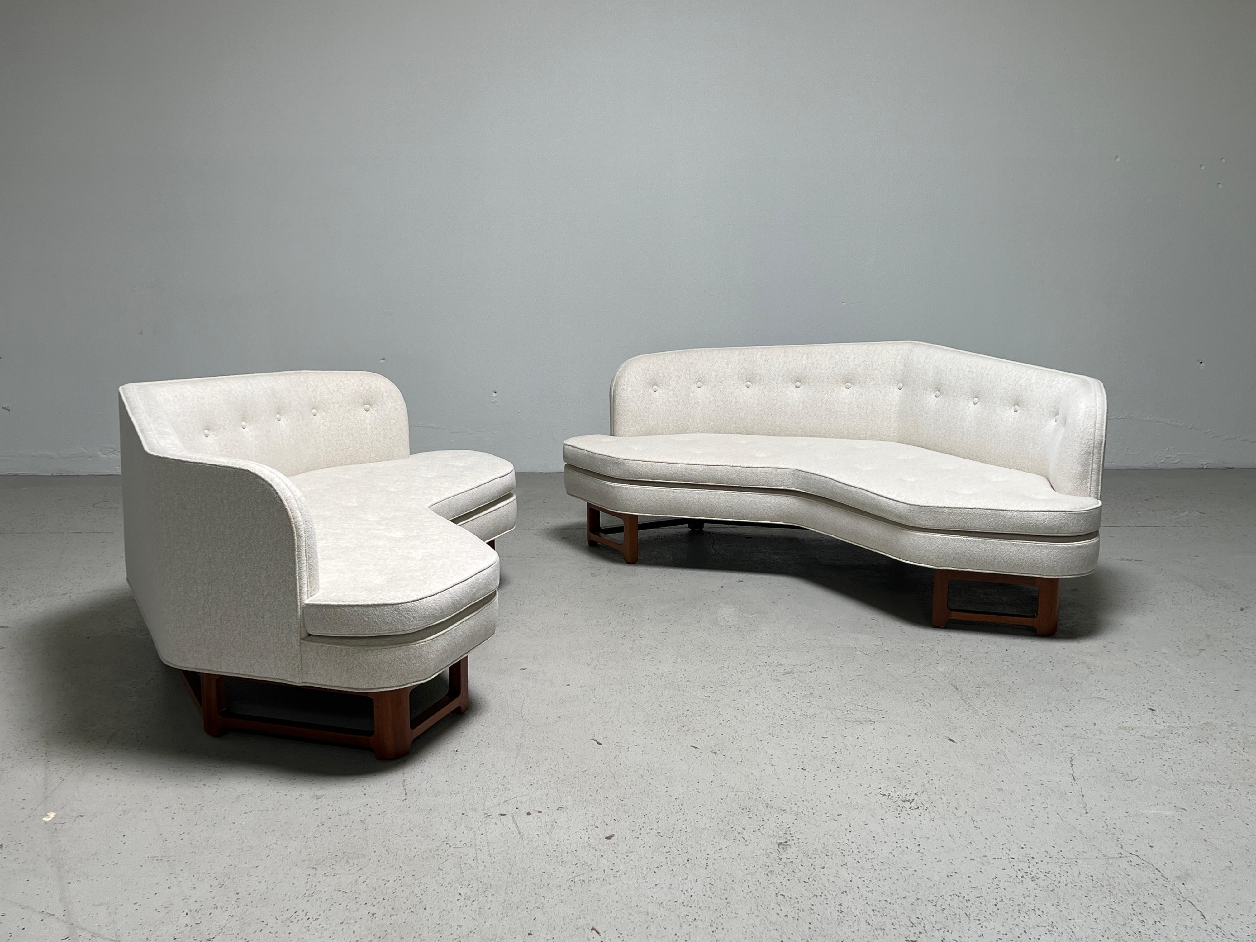 A matching pair of angled sofas designed by Edward Wormley for Dunbar. Beautifully restored with refinished mahogany bases and reupholstered in Larsen / Tsuga / Snow fabric.