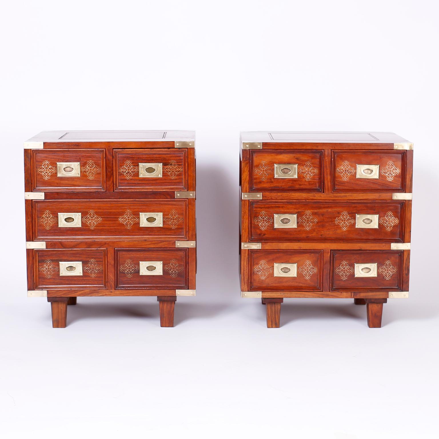 Pair of British colonial five-drawer stands crafted in indigenous rosewood with paneled sides and tops, brass campaign hardware, and featuring brass inlaid floral designs.