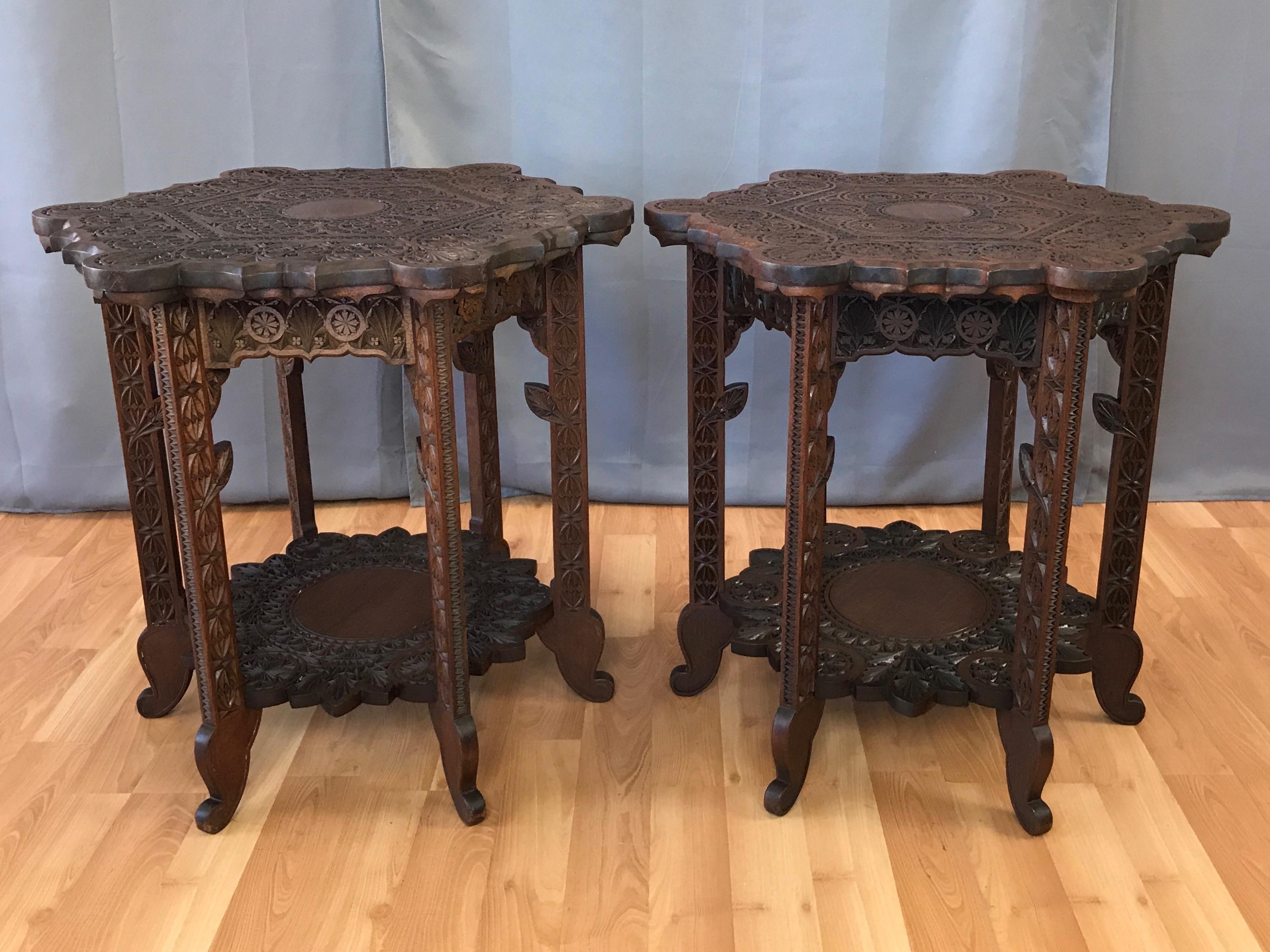 An exceptional pair of early 1900s Anglo-Indian hand carved rosewood two-tier side or end tables.

Astonishing level of meticulously executed craftsmanship decorates every inch, with delightful details on display from every angle. Hexagonal top with