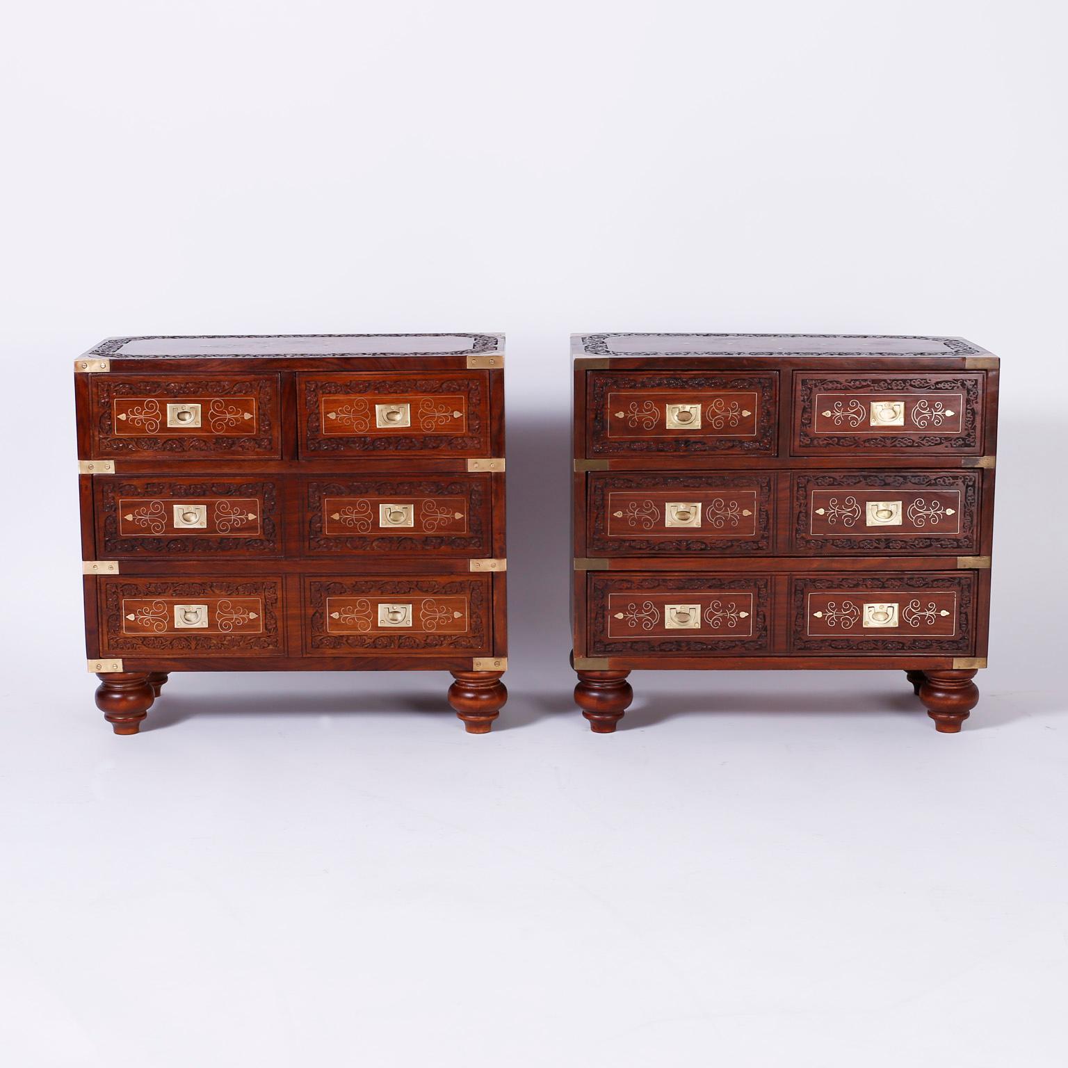 Inspired pair of Anglo-Indian mahogany stands or six-drawer chests with hand carved floral borders, symbolic brass string inlays on the top, front and sides, campaign style hardware, and classic turned feet.