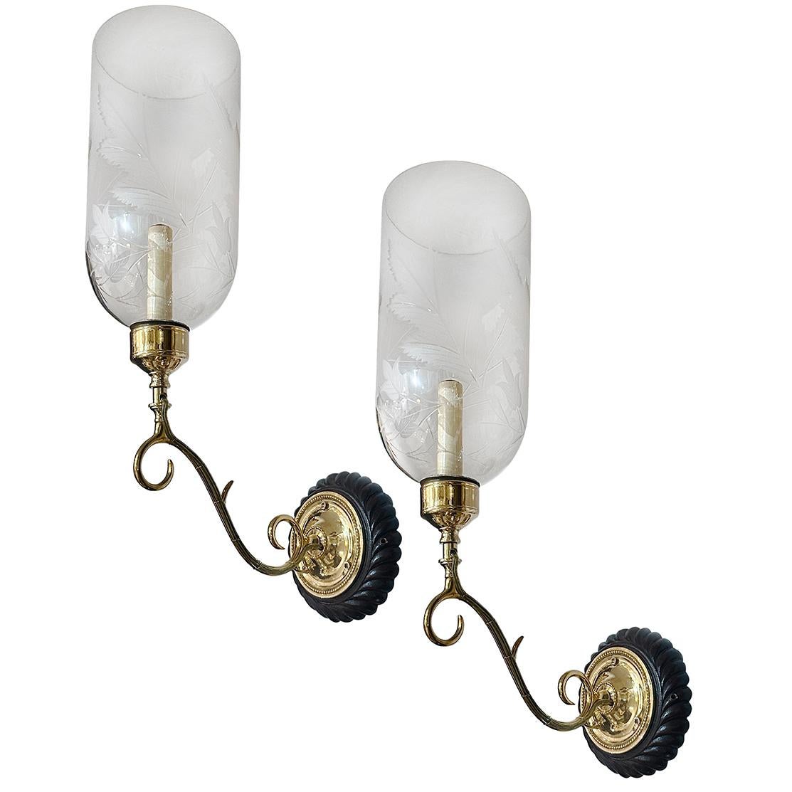 Coppia di appliques anglo-indiane a luce singola del 1920 circa con piastra posteriore in legno intagliato a mano e uragani in vetro trasparente con motivo a foglie incise.

Misure:
Altezza: 22